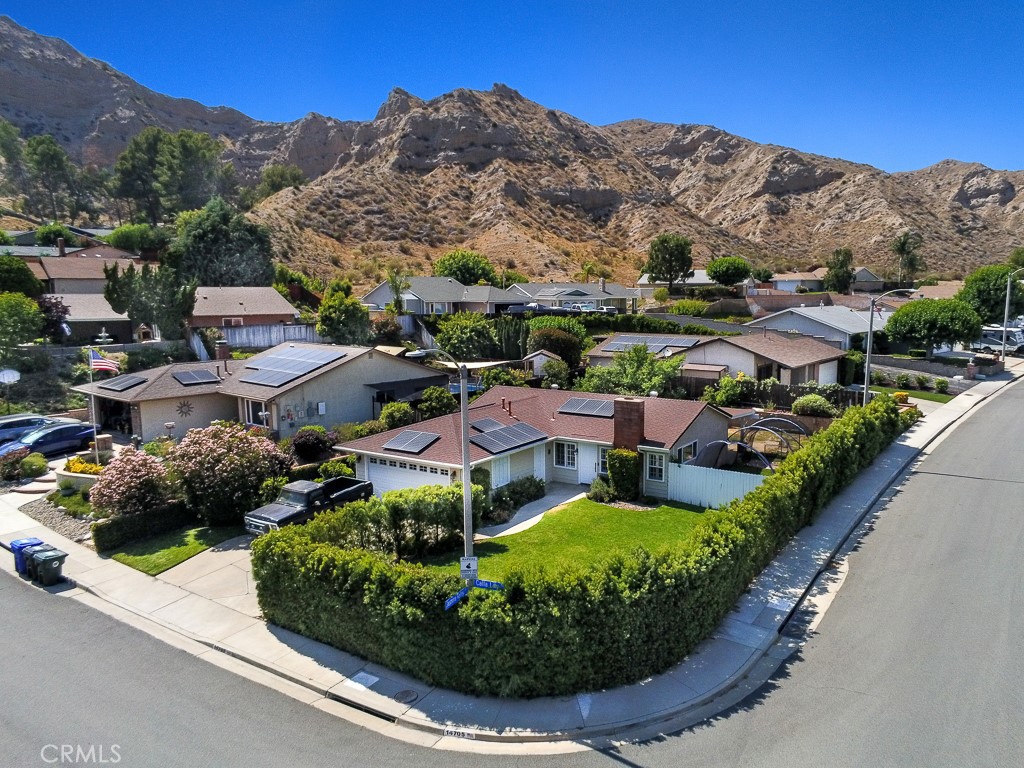 *** PAID SOLAR PANELS - NO HOA *** This beautiful home is nestled on a sweeping corner lot with fantastic views of the surrounding jagged hills in one of Santa Clarita’s most sought-after neighborhoods. As soon as you lay your eyes on its lush privacy landscaping and colorful planters you’ll immediately recognize the owner’s true Pride-Of-Ownership.” Here are just a few of its many other fine features: ** You’ll step into a flowing 1,000 square foot open concept floor plan that is in “Move-In-Condition” with recessed lighting, plantation shutters, and durable tile flooring ** The spacious living room is bathed in natural light from a multitude of windows and has a gas-burning fireplace ** The family’s cook is going to appreciate the kitchen ample cabinets, easy care tile counters
with full back-splash, built-in stainless steel appliances, stainless steel refrigerator, and the convenience of the adjoining dining area with its direct patio access ** 3 bedrooms; The main suite has a roomy mirrored closet, and well appointed bathroom ** A total of 2 bathrooms ** The washer and dryer are staying in the functionally located laundry area ** Energy efficient dual pane windows and PAID SOLAR PANELS will help keep your utility bills low ** Central heat & air for year-round comfort ** You’re going to appreciate and enjoy the backyard’s tall privacy fencing, large lawn, brick capped raised planters, peach and apple trees, covered entertainer’s patio with ceiling fan, and the handy storage shed ** Plenty of secure off street
parking on the oversized concrete driveway and in the 2 car direct access garage ** All of this sits on a large 6,848 square foot lot that is minutes away from schools, the College of The Canyons, grocery stores, shopping, restaurants, entertainment, and the 14 freeway. Is a must see !