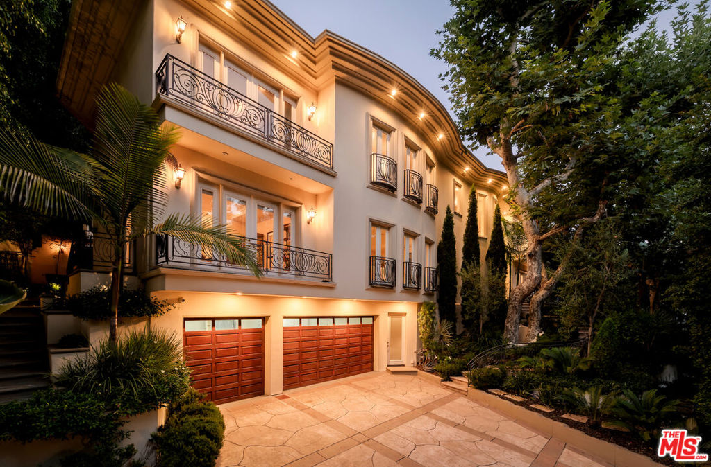 Positioned behind privacy gates amidst lush, verdant landscaping is this extensively remodeled Tuscan offering numerous amenities and updates throughout. Enter the motor court to experience beautifully designed and manicured gardens adorning the path to the home's elegant, towering double-door entry. Inside, a lofty double-height foyer is accented by an ornate chandelier and grand circular staircase. The formal living room features French doors and opens to the family room, perfect for entertaining. The updated kitchen is equipped with a large center island with prep sink, ample cabinetry, and state-of-the-art appliances including a Wolf range, Sub-Zero refrigerator, and Miele warming drawers, espresso machine, and dishwasher. A series of French doors in the formal dining room open to Juliet balconies to create a breezy al-fresco feel. The primary suite is expansive, with sitting area, private balcony, fireplace, dual voluminous walk-in closets with built-ins, and sumptuous spa-inspired bath. Secondary bedrooms are also beautiful and well-appointed, some also with private balconies. Other important features include a pajama room, office, wine cellar, theatre, and large lower-level lounge ideal for billiards, piano, and more. With wellness top of mind, there is also a massage room, sauna, and steam shower. The paradisal backyard is reminiscent of summers spent on holiday with a resort-like cabana/outdoor living room, adjacent built-in barbecue, shimmering pool with European lion head water spouts, spa with waterfall, ample lounging patios, and terraced garden. There is also a soothing fountain in the front yard, rounding out this wonderfully peaceful paradise. With its enchanting, secluded feel and close proximity to the city, there is no surprise that so many celebrities choose to call Benedict Canyon home. Welcome! This Four Seasons-inspired home is also available for sale at $9,895,000.