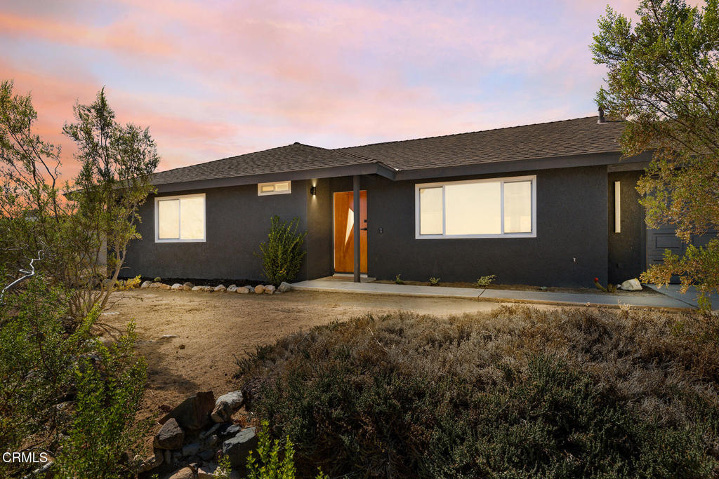 Tucked away in Joshua Tree's sought-after Friendly Hills neighborhood, 60815 Natoma Trail is a beautifully remodeled 2-bedroom, 2-bathroom home that blends modern style with desert charm. Built in 1986 and impeccably updated, it features an open-concept living space with designer tile, fresh paint, newer HVAC, and stylish fixtures throughout. The statement kitchen showcases a retro refrigerator, gas stove, dishwasher, and spacious breakfast bar, while sliding doors open to a covered patio overlooking an expansive backyard with a pergola--perfect for outdoor dining and entertaining. Situated on a 0.42-acre lot with room to add a hot tub, pool, or additional amenities, the property also includes an attached two-car garage offering convenience or potential for expansion. Other notable features include a charming built-in wet bar in the main living space and a generously sized primary suite with an en suite bath. Just minutes from the Joshua Tree National Park entrance and local favorites like Crossroads Cafe, Country Kitchen, The Dez, and the weekly farmers market, this thoughtfully designed home would make an ideal primary residence, vacation retreat, or investment property.