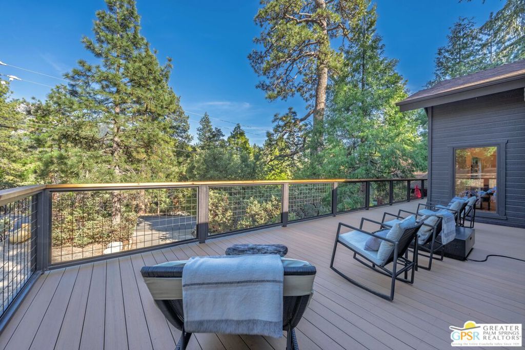 Highly renovated and impeccably maintained home in the sought after Cedar Glen neighborhood of Idyllwild. This 4 bedroom 3 bath home enjoys a location with easy access to all the picturesque Idyllwild hiking trails, including one just steps away. The home sits on a large lot set back amongst beautiful Cedar trees and natural landscaping enhanced by thoughtful Exterior Landscape Design. The backyard retreat features outdoor dining, an outdoor kitchen center and a newer Jacuzzi Hot Tub all surrounded by Idyllwild's natural beauty! But the piece de resistance is the new 650 sq ft TimberTech fire retardant deck on the front of the home with captivating views and endless outdoor entertaining. The fire pit on the deck is perfect for those chilly nights with a hot beverage! The exterior of the home has been repainted over fireproof siding for piece of mind. Inside you will find an open floor plan that is smartly designed and features well appointed modern lighting, hardwood floors and many other highlights listed in the Docs attached to the listing. The new HVAC split systems installed throughout the house give energy savings in both the summer and winter seasons. The garage has been converted to a fabulous gym space to keep you in shape while home, but can easily be converted back to a 2 car garage if you wish.The spacious interior has a special place for everyone in the family and when you want to all gather together there is a dining space we would all love to have! This home is perfect for your full time mountain home or vacation getaway and if you want it can be used as an investment property for rentals. Neighborhood, Outdoor Spaces, Views, Renovations, Sq Footage, Sold totally furnished per Inventory, Modern Design, Move-in-Ready all add up to.."what are you waiting for" Get your Idyllwild dream home now!!