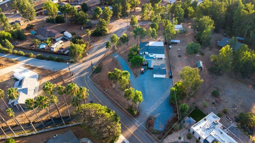 Modern Farmhouse on a corner acre lot! Beautiful 3 bedroom home with an open-concept kitchen with stainless steel appliances, all wood cabinets, quartz counters, bar seating, and a light-filled dining room. Spacious primary suite with walk-in closet & patio access. Features include dual-pane windows, shutters, laminate wood floors and designer touch finishes. Laundry room with full stackable washer & dyer. Enjoy the spacious remodeled back patio, a dining view deck, outdoor shower, and fully fenced grounds with room for animals or an ADU. Useable acre lot with endless opportunities with two different gates entrances. Detached insulated garage with AC and a sink, making it the perfect work area.  Extra storage with the storage container, RV parking & tons of space for entertaining.