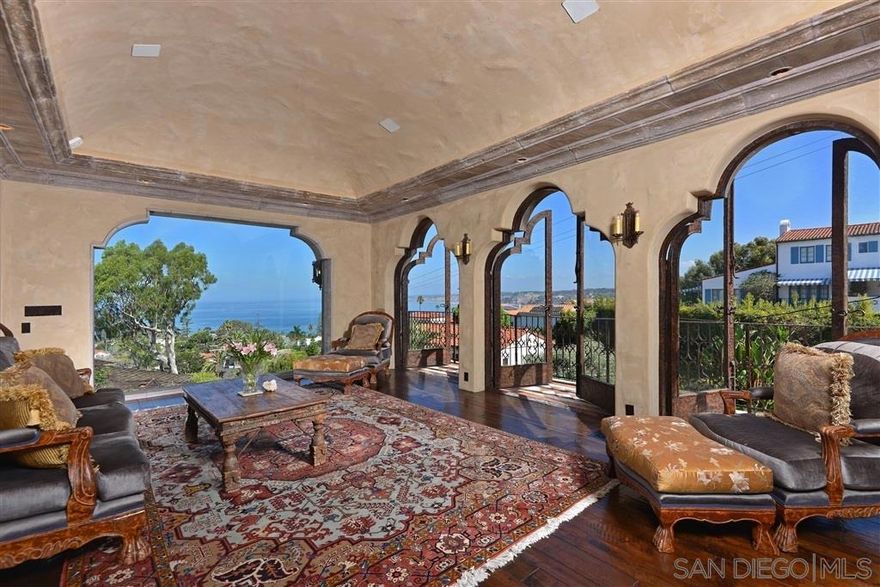Offered furnished with a 1-2 year lease. Resting on the renowned La Jolla Country Club golf course, this breathtaking villa is designed to capture awe-inspiring Pacific Ocean views. Meticulously appointed throughout, the residence showcases antique tiles imported from Spain, rich walnut wood floors, magnificent Moorish domes, and hand-crafted details including hand-chiseled Mexican Cantera stone and hand-honed oak doors with wrought-iron hardware. The upper-level living spaces maximize the panoramas, featuring a grand formal living room with a commanding stone fireplace that flows into a dining room overlooking the fairways. The well-equipped galley-style cook’s kitchen is complete with a convenient dumbwaiter. The main level hosts the primary suite and an additional bedroom, while the lower level offers two bedrooms (one with an armoire). Outdoor living evokes European charm with a loggia, serene garden yard, private view balconies, and multiple fountains, all surrounded by beautiful landscaping. Parking consists of a two-car garage plus off-street spaces. Perfectly positioned in La Jolla’s coveted Country Club neighborhood, this exceptional home affords effortless access to the Village’s boutiques and dining, La Jolla Cove, La Jolla Shores, UCSD, and more—an extraordinary opportunity to lease refined coastal living in one of Southern California’s most sought-after locales.