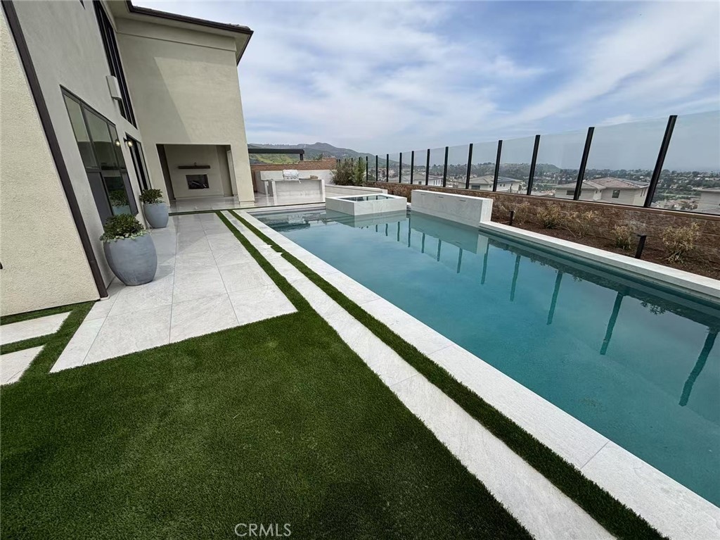 Your Private Escape with Contemporary Finishes – Now with Completed Pool & Landscaping
Step into your dream lifestyle at 20138 West Marlow, where the newly completed custom-designed pool, elevated square spa, and fully landscaped backyard create a stunning outdoor retreat. The sleek, modern linear pool—set against white marbled tile—features a deep blue finish that reflects the sky and complements the surrounding mountain views. Designed for both luxury and entertaining, this space offers the kind of picturesque living desired by many.
Located within the guard-gated Westcliffe at Porter Ranch community, this home continues to impress with highly upgraded finishes throughout. The main-level hard flooring adds elegance and cohesion to the bright layout, highlighted by soaring ceilings and natural light. A chef’s kitchen is fully equipped with quartz countertops, soft-close cabinetry, a large central island, a wine fridge, and high-end appliances: perfect for hosting guests or casual family dinners. In the living room, a mounted flat-screen TV and statement fireplace offer both function and style. Step outside to a fully appointed backyard complete with a BBQ area and two striking palm trees that enhance the home’s striking curb appeal.
The primary suite offers a spa-inspired experience with a deep soaking tub, oversized glass-enclosed shower, dual vanities, and an exceptionally spacious walk-in closet—offering more space than typically found in standard builds. Each room provides both comfort and flexibility, ideal for families, creatives, or professionals looking for a serene and elevated home environment.
This home is the definition of lavish—perfect for entertaining, relaxing, and living beautifully.
Don't miss this opportunity. Schedule your private showing today!