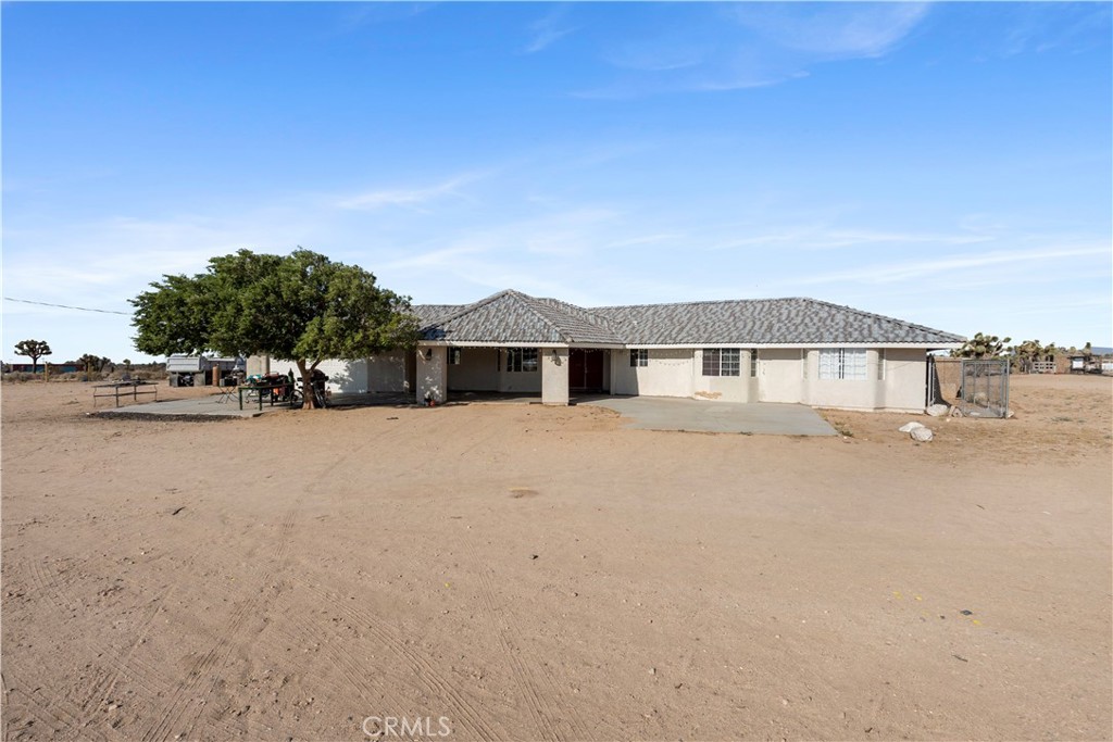 Welcome to 11025 Sonora Road, a charming 4-bedroom, 2-bath single-story home offering approximately 2,200 sq ft of living space on a fully fenced and usable 2.21-acre lot in the peaceful high desert of Phelan. This well-maintained property features a spacious living room with a cozy corner rock hearth, a formal dining area, and a versatile den with French doors that open to the covered back patio—perfect for relaxing or creating a home office. The kitchen is open and functional, complete with granite countertops, ample cabinetry, and a walk-in pantry. The large primary suite includes a generous walk-in closet, dual sinks, a walk-in shower, and a separate soaking tub. The hall bath also offers dual sinks and a tub-shower combo. Enjoy both front and rear covered patios, ideal for outdoor entertaining or simply taking in the breathtaking views of the surrounding mountains and open desert. With ample space for animals, RV parking, or future additions, the lot offers endless potential. Located less than a mile from paved Wilson Ranch Road and just minutes to Hesperia, Victorville, Wrightwood, and Mountain High Resort, this home blends rural privacy with commuter convenience. Come experience the tranquility and possibilities this Phelan gem has to offer.