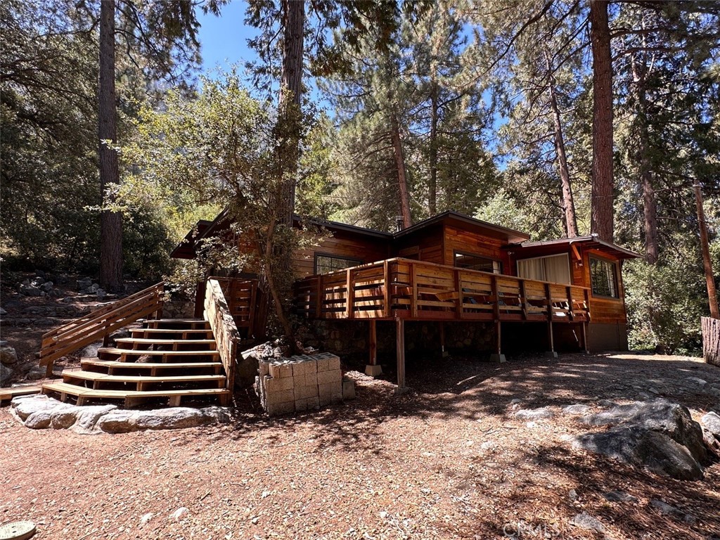 Adorable home sitting up high on .82 acres in the lower Canyon is this charmer that shouldn't be missed! Master bedroom, has big windows leading out to big deck with fabulous views of the San Bernardino Peak. Deck wraps around the front with built in bench seats to host that perfect Summer Soiree. Fresh paint and new flooring make this house fresh clean and easy to live in. Kitchen opens into formal dining room with access to back or side yards. Nice big bathroom is fresh clean and large for a mountain cabin. Surrounded by all the land that you own its quite private. Detached 2 car garage on lower level, while upstairs has the potential to be an, ADU a workshop or whatever your vision holds.