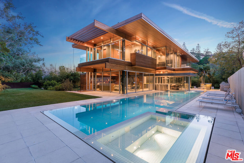 Reduced and motivated to sell. Welcome to 1160 San Ysidro Drive - A contemporary estate designed and built by acclaimed architect Ray Kappe, FAIA. This newly built property, boasting 6 bedrooms and 9 bathrooms across 9,000 square feet, is the epitome of warm, livable modern design. Set back behind gates up a long driveway on a 30,000 square foot flat lot, the home is incredibly private. Exterior features include expansive lawns, inviting outdoor patios, a fully equipped outdoor kitchen, a detached guest house, 60-foot pool, full sports and Pickleball court, and a panoramic viewing deck. Inside the house, concrete, teak, redwood, and walls of glass blend to create the perfect Southern California indoor/outdoor lifestyle. Interior highlights include a custom Bulthaup kitchen, home gym, home theater, climate controlled wine cellar, vast art walls, glass elevator, and a 3-car garage with motor court parking for 10. Fleetwood sliding glass doors across the main level allow for large scale or intimate entertaining/gatherings both inside and outside. The home also features an incredible primary suite with two private decks, dual walk-in closets and views of the city, canyon and ocean. All additional bedrooms have walk-ins and ensuite bathrooms with views of the lush yard, pool and surrounding canyons. An incredible home now offered at an incredible value.