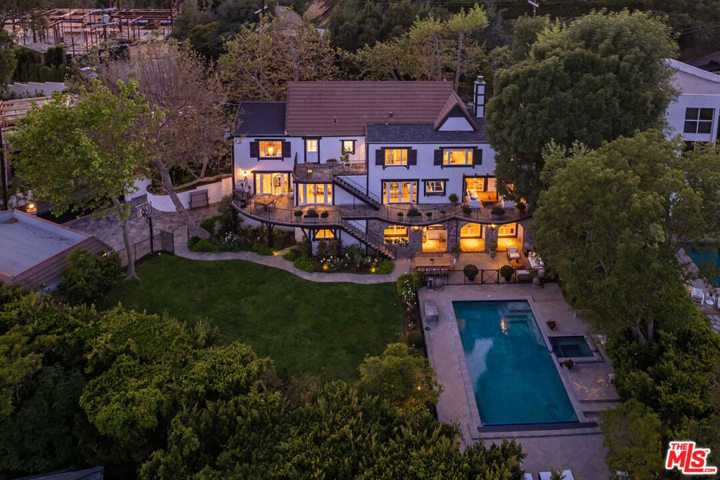 Welcome to 1756 Correa Way, an impeccably renovated family home located on a quiet cul-de-sac in prime lower Mandeville Canyon. This exceptional property on almost half an acre has been extensively renovated to today's contemporary design while preserving its original charm and character. It boasts architectural features and offers expansive views from the Getty to the Pacific Ocean, visible from every room in the house. The modern kitchen features high-end stainless steel appliances, marble countertops, and ample cabinet space. Upstairs, you'll find a spacious primary bedroom with an oversized bathroom and a walk-in closet, providing a true retreat. Down the hall, there are two additional bedrooms that open to a large stone patio overlooking the beautiful city views. The lower level features three additional bedrooms and a family room with a built-in bar and fireplace. This area opens to an additional covered stone patio adjacent to the fenced and heated swimmer's pool with spa and the expansive flat grassy lawn, which is great for pets and kids. With six generously sized bedrooms in total, this home offers comfort and tranquility. The very private backyard oasis boasts a spacious patio, including al fresco dining and summer barbecues. Designed as an entertainer's dream, the outdoor yard is ideal for hosting gatherings and parties. Located near top-rated schools, Brentwood Country Mart, and Santa Monica's famous Montana Avenue, 1756 Correa Way combines classic charm with contemporary features.