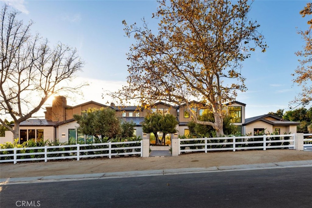 Completed in 2025, this stunning custom estate is sited in the prime Ashley Ridge section of Hidden Hills and features panoramic pastoral & sunset views! Sited on a beautiful, almost all flat 1.2-acre lot, this home offers a rare blend of modern elegance & timeless design. Spanning approximately 14,850' of luxury living space, highlights of the sunny, open floor plan include soaring ceilings & sliding walls of glass that open to the private & spacious grounds, plus a beautiful chef's kitchen with two islands & counter seating, a separate full prep kitchen, big breakfast room, spacious family room with an artistic fireplace, entertainer's lounge with wet bar, formal dining room, custom office, media room, and a truly amazing, glass encased gym with steam, sauna, indoor spa and cold plunge! There are five bedrooms in the main house, including the gorgeous primary suite with all stone bath, two superb, oversize walk-in closets and a walk-out balcony showcasing the endless sunset views. There is also a separate two bedroom and two bath guest house complete with a full kitchen, plus there is approval for a future barn if desired. The superbly private grounds offer loads of off-street parking, a sparkling pool with fountains and large adjoining spa, a full barbecue center, lush grassy areas, mature trees, and wide-open pastoral and sunset views. Located conveniently close to the highly rated public & private schools, excellent local restaurants, and the nearby beaches of Malibu, this beautifully built home has much to offer.