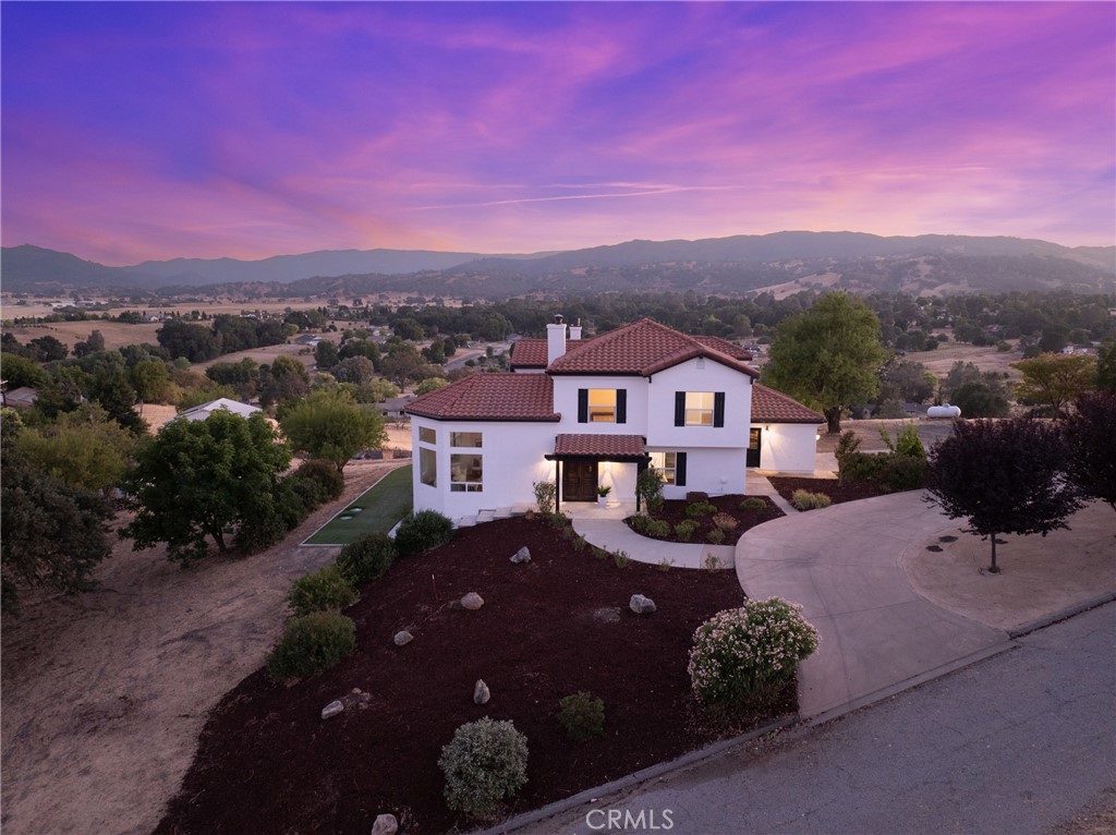 Introducing “Monte Sereno” – a recently renovated Spanish-style estate with a workshop, elegantly perched on 2.6 acres of usable land in the desirable Atascadero Colony neighborhood. This exceptional home showcases hardwood floors throughout, fresh paint, new fixtures, and modern updates that seamlessly blend with its timeless architectural charm. Perfectly positioned for panoramic 360-degree views, “Monte Sereno” offers both sophistication and serenity.
Upon entry, you are welcomed into a sunken living room, where soaring domed wood ceilings and expansive picture windows frame the stunning vistas. A grand stone fireplace anchors the space, creating a warm yet refined atmosphere. The open-concept dining area and kitchen are equally impressive, featuring beamed ceilings, French doors to the patio, and exquisite finishes including white wood cabinetry, stainless steel appliances, quartz countertops, a striking copper backsplash, a center island with built-in cooktop, and a double oven.
The main level also offers a well-appointed bedroom and full bathroom—ideal for guests or a versatile flex space. Upstairs, the luxurious primary suite showcases French doors leading to a private balcony, a spacious lounge or office area framed with windows, a generous walk-in closet, and a spa-like bathroom with a dual vanity, walk-in shower, and soaking tub surrounded by windows showcasing breathtaking views. Two additional bedrooms and a shared bathroom complete the upper level.
Outdoors, you’ll find a spacious patio and turf area designed for entertaining and relaxation. The expansive driveway offers ample space for RV, boat, or oversized vehicle parking, while a large metal shop provides endless possibilities for storage, hobbies, or projects.
Nestled in a quiet neighborhood on the edge of Atascadero near Santa Margarita, “Monte Sereno” combines seclusion with convenience. Just minutes from downtown Santa Margarita, only 8 minutes to Highway 101, and right off El Camino Real for easy access to Atascadero, the location offers the best of both worlds—tranquil living with connectivity.
Monte Sereno is more than a home—it’s a private retreat where timeless elegance meets modern luxury, designed for those who appreciate extraordinary living.