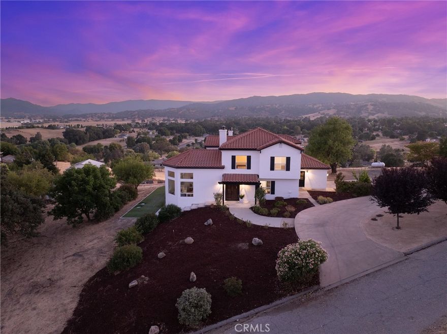 Introducing “Monte Sereno” – a recently renovated Spanish-style estate with a workshop, elegantly perched on 2.6 acres of usable land in the desirable Atascadero Colony neighborhood. This exceptional home showcases hardwood floors throughout, fresh paint, new fixtures, and modern updates that seamlessly blend with its timeless architectural charm. Perfectly positioned for panoramic 360-degree views, “Monte Sereno” offers both sophistication and serenity.

Upon entry, you are welcomed into a sunken living room, where soaring domed wood ceilings and expansive picture windows frame the stunning vistas. A grand stone fireplace anchors the space, creating a warm yet refined atmosphere. The open-concept dining area and kitchen are equally impressive, featuring beamed ceilings, French doors to the patio, and exquisite finishes including white wood cabinetry, stainless steel appliances, quartz countertops, a striking copper backsplash, a center island with built-in cooktop, and a double oven.

The main level also offers a well-appointed bedroom and full bathroom—ideal for guests or a versatile flex space. Upstairs, the luxurious primary suite showcases French doors leading to a private balcony, a spacious lounge or office area framed with windows, a generous walk-in closet, and a spa-like bathroom with a dual vanity, walk-in shower, and soaking tub surrounded by windows showcasing breathtaking views. Two additional bedrooms and a shared bathroom complete the upper level.

Outdoors, you’ll find a spacious patio and turf area designed for entertaining and relaxation. The expansive driveway offers ample space for RV, boat, or oversized vehicle parking, while a large metal shop provides endless possibilities for storage, hobbies, or projects.

Nestled in a quiet neighborhood on the edge of Atascadero near Santa Margarita, “Monte Sereno” combines seclusion with convenience. Just minutes from downtown Santa Margarita, only 8 minutes to Highway 101, and right off El Camino Real for easy access to Atascadero, the location offers the best of both worlds—tranquil living with connectivity.

Monte Sereno is more than a home—it’s a private retreat where timeless elegance meets modern luxury, designed for those who appreciate extraordinary living.