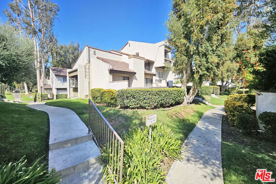 Spacious multi-level townhouse in a desirable gated community of Woodland Hills. The entry level features an open-concept living area with a cozy fireplace, dining area, breakfast bar, and a well-appointed kitchen. Sliding glass doors from the living room lead to a private patio perfect for relaxing or entertaining. A few steps up, the second level offers a versatile den (ideal as a family room or home office), a bedroom, a guest closet, and a full bath. The top level boasts a private master suite with vaulted ceilings, a second fireplace, generous closet space, and an en-suite bath. The attached garage provides ample storage cabinets and a laundry area for added convenience. Community amenities include a sparkling swimming pool and tennis court. Conveniently located near Warner Center, shopping, dining, and freeway access.