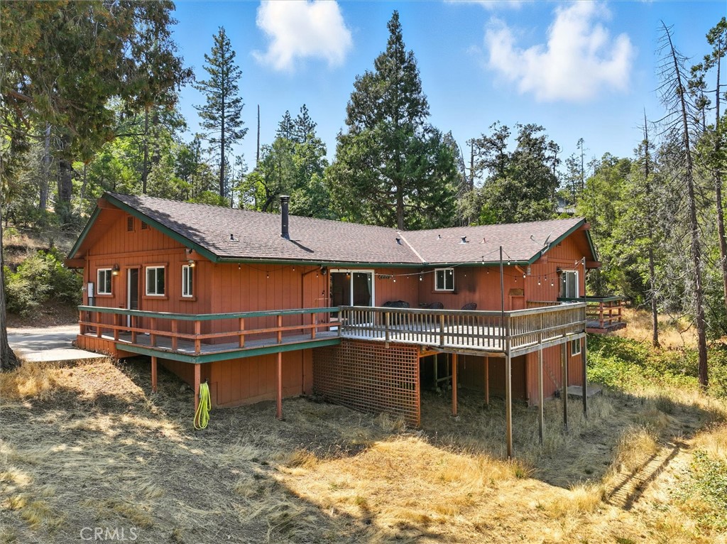Secluded yet convenient, this mountain retreat is just minutes from Bass Lake, the town of Oakhurst for dining and shopping, and the iconic Yosemite National Park.The 4-bedroom, 2.5-bath home has been lovingly maintained, with all primary living spaces on the main level and updated with PEX plumbing in 2012. An oversized 2-car garage with built-in shelving as well as an enclosed and temperature controlled storage or garden room, providing abundant storage, while the expansive deck is the perfect place to relax and enjoy fresh mountain air and wildlife.On the lower level, a 400 sq. ft. bonus room with a separate entrance adds flexibility—ideal for guests, a home office, hobby studio, or even rental income.Set on just under 3 acres of usable land with mountain views and two seasonal creeks, the property offers privacy and plenty of room for RV parking, an ADU, or the backyard of your dreams. With its combination of space, comfort, and future potential, this property offers a rare opportunity in the Sierra foothills.
