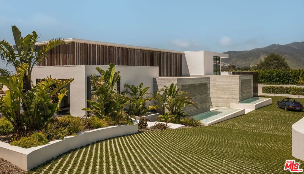 Introducing TerraLume, Malibu's newest iconic estate nestled within the ultra-exclusive Point Dume enclave. Spanning 2.25 acres of pristine grounds with commanding panoramic ocean views, this 8,500 sq ft, 6-bedroom, 8-bathroom masterwork offers the pinnacle of architectural sophistication and resort-style living. A harmonious fusion of contemporary design and materials, TerraLume features board-formed concrete walls, curated stone finishes, and floor-to-ceiling disappearing glass doors that seamlessly blend indoor and outdoor living. Highlighting Malibu's legendary sunsets at every turn. Enter through a tranquil lagoon to a grand 8x10 custom copper pivot door, leading into a dramatic double-height entry and voluminous open spaces. Every detail has been hand-selected for its artistry: handmade chandeliers, handcrafted wood louvers, etched copper walls, and a bespoke Italian kitchen. The floating staircase ascends to a private upper level featuring an opulent primary suite with two fireplaces, a spa-inspired bath retreat with hand-carved marble vanities, a sculptural stone soaking tub, and a steam shower framing unforgettable ocean vistas. Outdoor amenities rival world-class resorts: a covered outdoor kitchen and bar, 70-foot pool and spa, detached guesthouse, fitness studio with sauna, and gated motor court with parking for up to 20 vehicles. Enjoy private access to Little Dume Beach through the coveted Riviera III beach key.