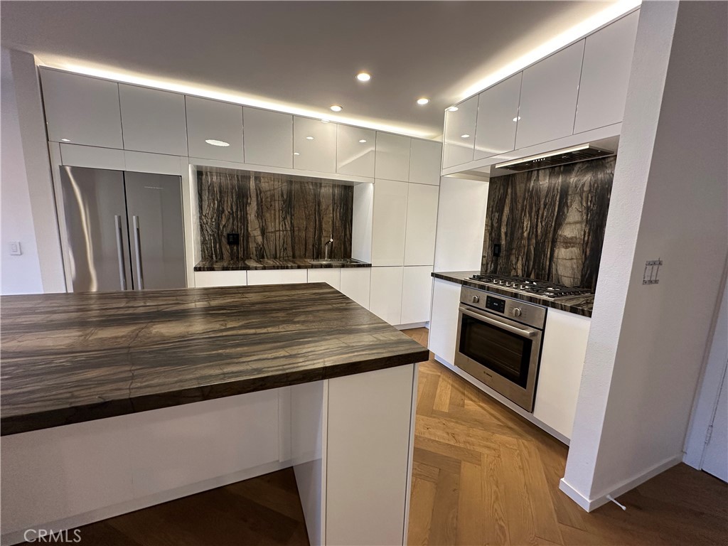 Remodeled Top-Floor 2-Bedroom Condo in Prime Glendale Location! The spacious 2-bed, 1-bath condo (1000 sq. ft.) has been beautifully redesigned and remodeled with high-end finishes. It is centrally located in one of Glendale’s most desirable neighborhoods—walking distance from The Americana at Brand, Brand Boulevard’s vibrant shops, Whole Foods, Erewhon (coming soon), cafes, restaurants, and easy freeway access. Light-Filled, Private, and Move-In Ready. Set on the top floor, looking onto the courtyard – it is an oasis of calm and serenity in an urban environment. The single-level home (accessible by elevator or stairs) is bathed in natural South light, filtering in through expansive sliding glass doors off the living room that open to a private balcony. Step inside to discover a modern, designer interior featuring: elegant herringbone Hickory wood floors, modern recessed lighting and controllers, fresh new paint, woodwork and hardware throughout. A fully remodeled kitchen with new soft-close cabinetry, leathered quartzite countertops, designer hardware, and high-end appliances including a Bosch gas range, panel-ready dishwasher, and Fisher & Paykel stainless steel refrigerator. Elegant Bathroom & Functional Comforts. The spacious luxurious bathroom with floor to ceiling tile is a retreat, boasting a soaking tub, separate standing shower, and floating vanity with mirrored cabinet and Delta fixtures. Enjoy year-round comfort with central air and heat, plus the convenience of an in-unit LG washer/dryer (included). The primary bedroom features a large double row walk-in closet with custom shelving for ample storage. Amenities & Convenience: One assigned parking space near the elevator (Parking Space #95), private storage box on the same floor as the unit, gated complex with controlled access, security cameras, pool, BBQ area, multiple elevators and entrance lobby. Low $400/month HOA includes water, insurance, and common area maintenance. A Rare Find in the Heart of Glendale. This beautifully updated condo offers you the opportunity for stylish, low-maintenance living in an unbeatable location. Don’t miss your chance to own this turnkey gem.