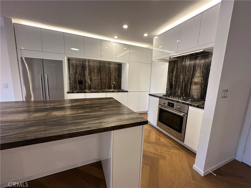 Remodeled Top-Floor 2-Bedroom Condo in Prime Glendale Location! The spacious 2-bed, 1-bath condo (1000 sq. ft.) has been beautifully redesigned and remodeled with high-end finishes. It is centrally located in one of Glendale’s most desirable neighborhoods—walking distance from The Americana at Brand, Brand Boulevard’s vibrant shops, Whole Foods, Erewhon (coming soon), cafes, restaurants, and easy freeway access. Light-Filled, Private, and Move-In Ready. Set on the top floor, looking onto the courtyard – it is an oasis of calm and serenity in an urban environment. The single-level home (accessible by elevator or stairs) is bathed in natural South light, filtering in through expansive sliding glass doors off the living room that open to a private balcony. Step inside to discover a modern, designer interior featuring: elegant herringbone Hickory wood floors, modern recessed lighting and controllers, fresh new paint, woodwork and hardware throughout. A fully remodeled kitchen with new soft-close cabinetry, leathered quartzite countertops, designer hardware, and high-end appliances including a Bosch gas range, panel-ready dishwasher, and Fisher & Paykel stainless steel refrigerator. Elegant Bathroom & Functional Comforts. The spacious luxurious bathroom with floor to ceiling tile is a retreat, boasting a soaking tub, separate standing shower, and floating vanity with mirrored cabinet and Delta fixtures. Enjoy year-round comfort with central air and heat, plus the convenience of an in-unit LG washer/dryer (included). The primary bedroom features a large double row walk-in closet with custom shelving for ample storage. Amenities & Convenience: One assigned parking space near the elevator (Parking Space #95), private storage box on the same floor as the unit, gated complex with controlled access, security cameras, pool, BBQ area, multiple elevators and entrance lobby. Low $400/month HOA includes water, insurance, and common area maintenance. A Rare Find in the Heart of Glendale. This beautifully updated condo offers you the opportunity for stylish, low-maintenance living in an unbeatable location. Don’t miss your chance to own this turnkey gem.