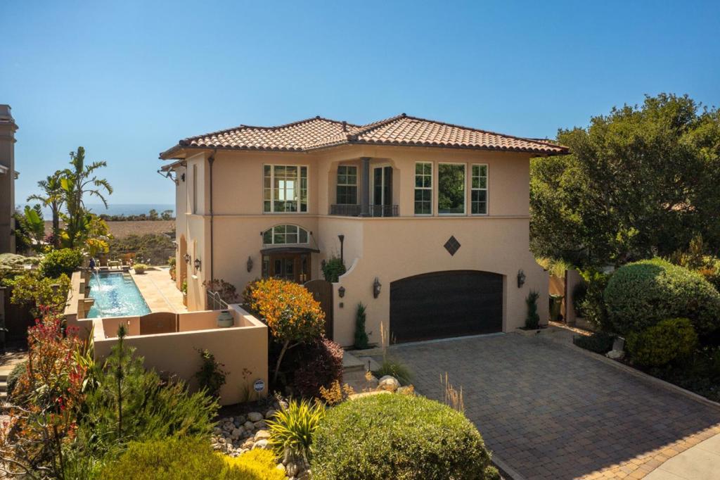 Nestled within an exclusive gated community, this stunning 3-bedroom, 3+bath residence offers breathtaking ocean views and unforgettable sunsets. The thoughtfully designed reverse floor plan takes full advantage of the sweeping vistas, filling the home with natural light. As you step inside, you'll be drawn to the handcrafted metal staircase that leads to the expansive upstairs great room -- the heart of the home. Here, you'll find custom cabinetry with abundant storage, top-tier appliances, including a Bosch dishwasher, GE Monogram refrigerator, double ovens, and a GE Profile microwave. Relax by the cozy fireplace or step onto the balcony to take in the fresh ocean breeze and view. The primary bedroom captures the morning sunrise and the occasional moonrise. An elevator brings you downstairs to a serene library and a spacious office, both featuring built-in cabinetry, plus two additional bedrooms, two bathrooms, a media area, and access to the outdoor kitchen overlooking the hot tub and sparkling lap pool. Entertain or unwind at the end of the day. Picture yourself watching the sun dip into the Pacific from your private spa. Conveniently located near Seascape, the beach, freeway, hiking trails, schools, shopping, and dining. Coastal living at its finest. Time to make it yours!
