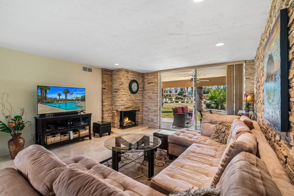 Beautifully updated and move-in ready! This 2-bedroom, 2-bath Sandpiper unit offers 1,300 square feet in a historically designated area of Sandpiper in Palm Desert. The condo features a combination of tile flooring in the main living areas and carpet in the bedrooms. Both bathrooms have been updated with granite countertops and walk-in showers with glass enclosures. The living room includes a corner fireplace rarely seen in this Sandpiper floor plan, and all of the living room walls are finished in a textured natural stack stone treatment in warm desert tones -- creating a clean, modern look with subtle depth and shadowing.The property underwent a full renovation by November 2020 with new kitchen cabinets and granite countertops, all-new flooring, complete interior repainting, a new main bathroom with vanities, and stainless-steel appliances. Kitchen and dining areas open onto a private patio with mountain views and a convenient laundry closet. Enjoy morning sun on your poolside patio overlooking a lush greenbelt with pool and mountain views -- perfect for outdoor entertaining and soaking up the desert lifestyle. It is also eligible for the Mills Act, offering potential property-tax savings. With a minimum one-week rental policy, the property is ideal for both personal enjoyment and rental opportunities. Located just minutes from El Paseo shopping, dining, hiking, and more. Unit is sold furnished and includes one covered carport parking space.