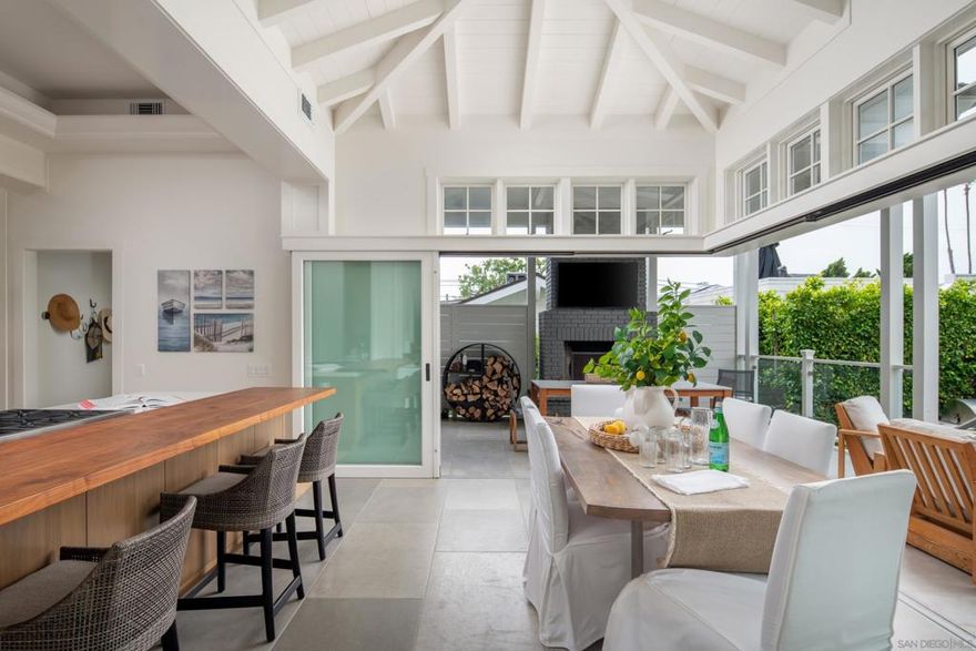 Floor to ceiling glass doors open seamlessly with a lift and slide design, exposing a 370-square-foot covered patio. Brick floors flow from the sunroom to the patio to further support the fluidity of the living space. The heart of the house is a gorgeous galley kitchen with white quartz countertops, a six burner Wolf range, and a Sub-Zero refrigerator. The exterior of the home exudes a traditional Cape Cod feeling with double-hand-dipped cedar shake shingles, while the interior features custom-milled board and batten walls, open-beamed ceilings, and crown molding, for a bright beachy aesthetic. The master bedroom features a cozy wood-burning fireplace with a marble surround and 12’ ceilings allowing natural light to flood the room. The master bath was designed with comfort and relaxation in mind with an over-sized steam shower and "Tea for Two" Kohler bathtub, and the gorgeous marble countertop gives the room a luxury feel. The indoor/outdoor living is unparalleled along the coast and was featured in Better Homes & Gardens Magazine! Entertain on the covered patio featuring a cozy, yet sophisticated, outdoor brick fireplace designed by architect Jim Sneed, or enjoy the additional 450-square-foot ipe wood deck. Both the patio and deck are surrounded for privacy by lush mature landscaping , and a custom outdoor shower is the perfect place to rinse salty bodies and sandy surfboards. There is nothing quite as extraordinary as 236 24th Street!