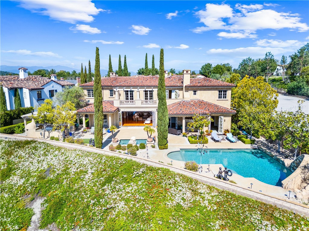 Luxury Italian Villa in a Prime Cul-de-Sac Location with Stunning Views
Located within the prestigious 24-hour guard-gated community of Covenant Hills in Ladera Ranch this spectacular home is nestled at the end of a peaceful cul-de-sac. This exquisite Italian villa-inspired estate offers the perfect blend of luxury, privacy, and functionality. Boasting 5 spacious bedrooms and 5.5 elegantly appointed bathrooms, this custom-designed single-family residence is the epitome of refined living.
Step inside and be captivated by the home’s thoughtful layout and timeless finishes. A gourmet kitchen with a butler’s pantry and wine refrigerator opens to a large family room, ideal for both intimate gatherings and grand entertaining. A dedicated office, bonus room, and wine cellar add to the home’s versatility, providing both relaxation and productivity spaces.
The heart of the home extends outdoors to a resort-style backyard, a true entertainer’s dream. Enjoy the sparkling pool and spa, outdoor TV area, and fully equipped built-in bar and cooking station—complete with its own refrigerator—perfect for year-round enjoyment. A charming courtyard adds a touch of European elegance.
Car enthusiasts and collectors will appreciate the five-car garage, offering ample space for vehicles, storage, or hobbies, and located at the end of the long driveway within the gates of another beautiful courtyard complete with a bubbling fountain.
Covenant Hills offers access to an array of wonderful amenities, including a 24-hour guard gate, clubhouse, water park, skate park, multiple pools, parks, and hiking and biking trails. What a great opportunity to experience all that Covenant Hills has to offer!!