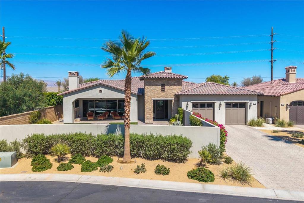 Experience refined desert living in this move-in ready residence located behind the gates of the world famous Greg Norman at PGA West. This impeccably maintained home sits in a small enclave of homes called Monterra at PGA West and boasts stunning honey honed wood flooring throughout, Kitchen aide appliances, designer textiles, and stylish finishes that exude warmth and sophistication. The spacious layout offers effortless indoor-outdoor living, with unobstructed mountain views that allow for beautiful sunsets, while a newly installed mini split system in the garage provides climate control for hobbies, storage, or fitness.Backed by a builder warranty with Woodbridge Homes, because this home was built in 2019 this property offers peace of mind and pride of ownership. With one of the lowest HOA fees in all of PGA West communities, this property delivers exceptional value with access to the Greg Norman club house and six other sparkling community pools--perfect for soaking up the sun and embracing the resort lifestyle. An inspection report is available, making this an easy and confident choice for discerning buyers.
