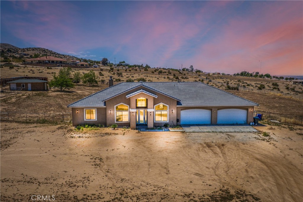 COVETED MARIANA RANCHOS ADJACENT in Apple Valley, with RARE 2.5 ACRE RANCH A-1 zoning (most are 1 acre or less!), Custom Workshop with POWER, 4-Car Garage, and perhaps most importantly a RENOVATED INTERIOR!!! This is the COMPLETE home. From the moment you arrive, it’s clear this is something special, offering unobstructed 360-degree views of the surrounding mountains by day, and a sparkling valley skyline at night.
Step through a grand front entry and into a thoughtfully renovated home where comfort meets style. Inside, new tile flooring, remote-controlled lighting and ceiling fans, and custom French doors with built-in blinds set the tone for quality and attention to detail. The spacious living area flows seamlessly into a stunning kitchen featuring a huge center island, custom pewter-glazed cabinetry, double dishwasher drawers, and a fogged-glass walk-in pantry.
The home’s layout is as functional as it is elegant. The primary suite offers true retreat vibes with double-door entry, a walk-in, no-door tiled shower with alcove seating, a soaking tub with a dual-sided remote fireplace, and a large walk-in closet. Two additional bedrooms are connected by a Jack-and-Jill bathroom, while a study and separate den provide flexible living or work space—one even includes a built-in Cannon gun safe.
Outdoors, the property continues to impress. In addition to the oversized 4-car garage, you’ll find a tile-roofed, fully powered workshop, and room for animals, equipment, or future expansion. A horse corral with shelter and auto Lipper system, cross fencing, four double gates (one electric), and a private well with multiple water valves make it incredibly functional and self-sufficient. A 500-gallon propane tank, two roll-up garage doors, and dual A/C units round out the thoughtful amenities.
This is more than just a home—it’s a lifestyle. With a rare combination of acreage, location, and truly usable upgrades, this property is the ideal choice for anyone looking to enjoy space, privacy, and flexibility without sacrificing comfort or convenience.