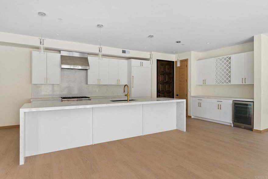 NEW CONSTRUCTION – Beautiful single-level (no stairs), first-floor unit at Roosevelt Nine Condos. Home features an open-concept true chef’s kitchen showcasing an oversized island, white custom European slab-style cabinets, Thermador appliances (fridge and dishwasher paneled to match), gold hardware, a Kohler touchless faucet, and a professional-grade Thermador hood vent. Corian Quartz counters, matching backsplash, and a dramatic waterfall island create a modern, high-end look. Dining area includes a large custom built-in seating bench with extra storage. Solid core doors from Urban Doors and matching wood baseboards run throughout, complemented by luxury motorized window treatments in bedrooms.  Spacious primary suite offers a large sliding glass door opening to the private backyard and filling the room with natural light. Attached primary bathroom features designer tile, a custom glass shower enclosure, and a fully built-out walk-in closet.  Located in the heart of Carlsbad Village, this home is a short stroll to countless dining options ranging from Michelin-rated restaurants like Jeune et Jolie and Lilo to casual favorites like Pure Taco and everything in between. The large, side-by-side attached garage (424 sf) will include epoxy flooring and custom storage cabinets, along with an EV outlet for car charging. Comes with owned solar.  Unit is complete and power / gas are on. This an incredible opportunity to move into a highly upgraded brand-new home in one of Carlsbad’s most vibrant neighborhoods.