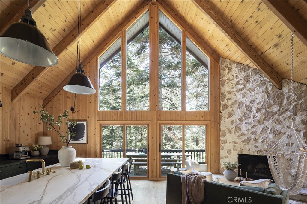 Welcome to the Modern Lodge. A dreamy designer cabin tucked in the trees of the San Bernardino Mountains. This 3 bedroom, 2 bath retreat has been fully renovated and professionally designed by Sarah Solis, blending natural textures, rich tones, and high end finishes into a space that feels warm, moody, and intentional. Every inch has been curated, from the custom tile and warm woodwork to the top of the line appliances and luxe fixtures, including Waterworks faucets. Defining the living space is a beautiful floor to ceiling stone fireplace, designed for slow mornings, cold winter nights, and cozy conversations. Expansive windows bring the outside in, framing forest views and filling the home with natural light. With updated plumbing, electrical, and HVAC, it’s just as dialed in behind the walls as it is in the design. Tucked on a peaceful, county maintained road near the golf course, and just minutes from the Village, Snow Valley, and SkyPark, you’re perfectly positioned for year round adventure. And yes, lake rights are included! A full time retreat. A weekend escape. A stylish, fully furnished property with income potential. This one’s a rare find.