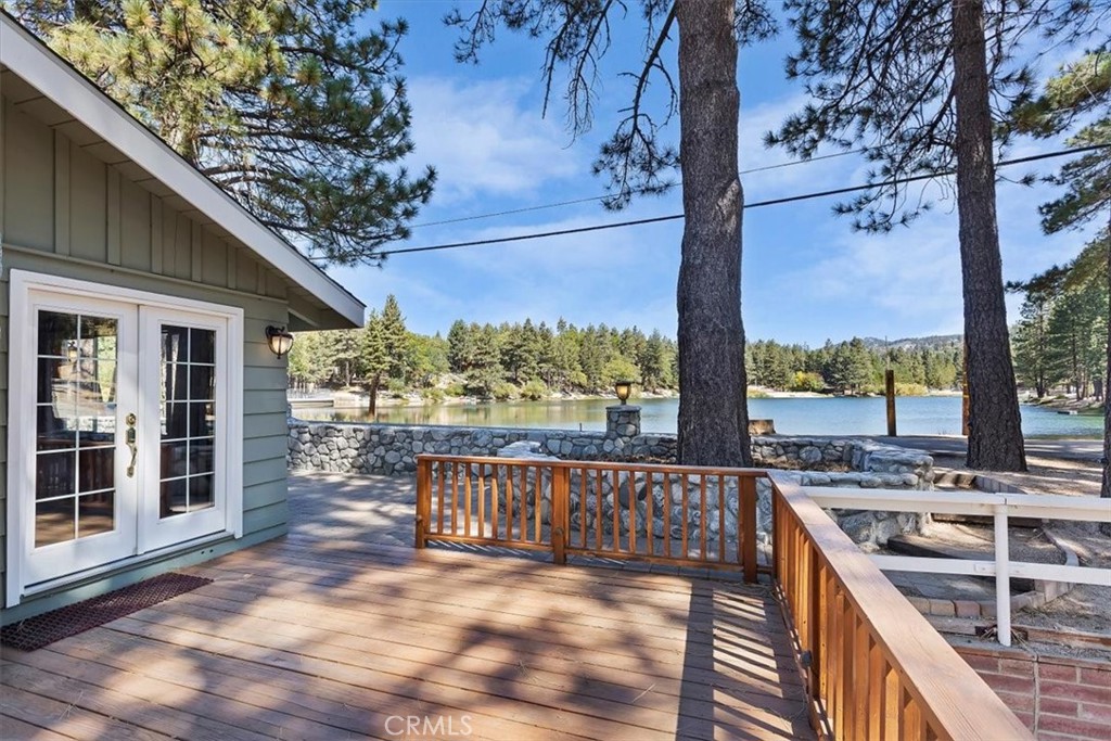 First time on the market ONE OF A KIND PROPERTY! Adorable cabin with a VIEW of the LAKE right from your living WINDOW! This is the best location in Green Valley Lake with an unobstructed view of the lake. Walk out of your front door 15 feet and throw a fishing pole right into the lake! This cabin has a perfect set up for a short term rental or family home! Can't do stairs, this one is perfect. The driveway, kitchen, 2 decks/patios, living room 2 bedroom's and 1 bathroom are all on the main level! Perfect if you can not do stairs or have bad knees! Sit back on the newly refinished patio and listen to the woodpeckers peck, watch the squirrels and listen to the tree blow in the breeze. This peaceful and tranquil location is ideal for relaxation and a great place to unwind. Includes a paddle boat and row boat for the lake. Green Valley Lake has fishing, boating, biking, hiking and park. This location is walking distance to everything that Green Valley has to offer. No need to drive around from this location. Seller just repainted the entire exterior and re stained the deck. As you walk in you will love the high beamed ceilings and the natural wood ceiling and walls making this cabin a cozy cabin feel. There is a wood burning rock fireplace. You have 2 decks off the living room. First deck is a perfect place to BBQ and gather while overlooking the lake. Second deck overlooks the backyard and the woods. Two great place to gather and relax. Brand new stove just installed. The kitchen has a wood bar that overlooks the living room perfect for gathering and eating together. Downstairs is 2 bedrooms, game room (POOL TABLE INCLUDED) , a secondary living room and bathroom. Indoor laundry makes it convenient for everyone. This is a large cabin that can accommodate a lot of people. There is a large backyard with a carport perfect for parking and storage. There is an extra storage shed separated perfect to store your Airbnb supplies, snow toys and tools. You won't want to miss out on this ONE OF A KIND PROPERTY!
