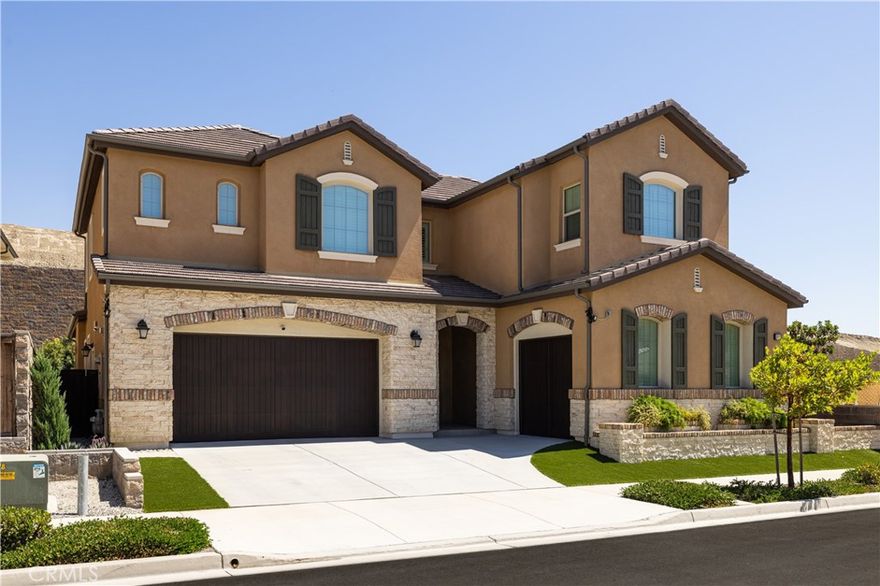 Newly built in 2022 within the coveted gated community of The Oaks at Portola Hills, this residence blends fresh contemporary design with everyday comfort.



Under soaring ceilings, the great room opens through pocket sliding doors to the private backyard, creating a seamless indoor-outdoor connection. The kitchen features quartz countertops, a stone and porcelain mosaic backsplash, soft-close cabinets, a large eat-in island, and a walk-in pantry plumbed for a beverage cooler. Commercial-grade KitchenAid appliances include a six-burner gas cooktop with built-in electric grill and two full built-in ovens—all complemented by a fireplace-warmed dining area with a custom built-in lighted china cabinet, complete with remote and granite top. Flanking the fireplace, additional built-in displays with granite tops add style and function.



Smart features include a motorized kitchen shade (remote- and app-controlled), a solar screen at the California room, and three Enviroblind security shields at the kitchen, California room, and downstairs primary slider—each with remote and hand-crank operation. Waterproof rigid core luxury vinyl oak plank flooring on the main level and primary bath, plantation shutters, and quartz finishes elevate the interiors.



The main-level primary suite opens directly to the backyard and offers a spa-like bath with limestone slab-topped dual sinks, a walk-in shower, and a freestanding soaking tub. Upstairs, an en suite bedroom serves as a second primary, while a loft/media room provides space for entertaining or a home office. Two secondary bedrooms, currently used as offices, feature updated baths with quartz finishes and glass closures.



The backyard combines stone and turf for an inviting, low-maintenance retreat. Additional highlights include seller-owned solar, Honeywell-controlled thermostats and garage doors, EV charging, instant hot water call buttons, and two garages: a two-car garage finished with marble-style epoxy flooring, plus a separate one-car garage ideal for parking or storage.



Residents of The Oaks enjoy resort-style amenities, including a pool, clubhouse, BBQ area, dog parks, sports courts, and over 1.5 miles of hiking trails with sweeping views of Lake Forest and Trabuco Canyon. Convenient access to the 241 Toll Road and proximity to Irvine Spectrum complete this exceptional offering.