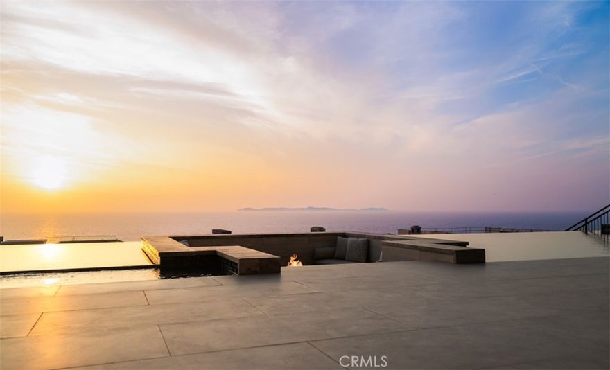 Perched within the exclusive, guard-gated enclave of The Strand at Headlands, 7 Pacific Waves Circle presents a rare opportunity to own a striking coastal retreat in the lower Strand, defined by modern architecture, privacy, and commanding ocean views. Thoughtfully designed to capture the beauty of Dana Point’s coastline, the residence offers a seamless blend of modern sophistication and effortless indoor–outdoor living. From the moment you enter, sweeping Pacific and Catalina Island vistas set the tone. Expansive walls of glass frame the main living spaces, allowing natural light and ocean breezes to pour throughout the home. The open-concept main level is designed for both elevated entertaining and everyday comfort, anchored by a showpiece kitchen featuring premium appliances, a statement island, and refined custom finishes. Adjacent living and dining areas flow seamlessly to generous outdoor terraces, creating an ideal setting for gatherings at any scale. The upper level is dedicated to tranquility, with a luxurious primary suite that enjoys panoramic ocean views, a private terrace, spa-inspired bath, and an oversized walk-in closet. Additional guest suites are thoughtfully positioned throughout the home to provide privacy and comfort for family and visitors alike. The lower level is a true entertainer’s retreat, offering a cinematic media lounge, secondary living space, gym with sauna and steam room, highlighted by effortless access to the resort-style backyard. Outdoors, the infinity-edge pool with sunken seating area, spa, fire features, and multiple lounging areas create an environment that feels both intimate and grand, perfect for entertaining or unwinding against the backdrop of the Pacific. Completing the residence are premium amenities including an elevator, smart home technology, and a spacious multi-car garage. Residents of The Strand enjoy exclusive access to the beach, coastal trails, and resort-style amenities, all just moments from the charm, dining, and harbor of Dana Point. A rare blend of modern architecture, prime guard-gated location, and California beach lifestyle, 7 Pacific Waves Circle represents coastal living at its highest level.