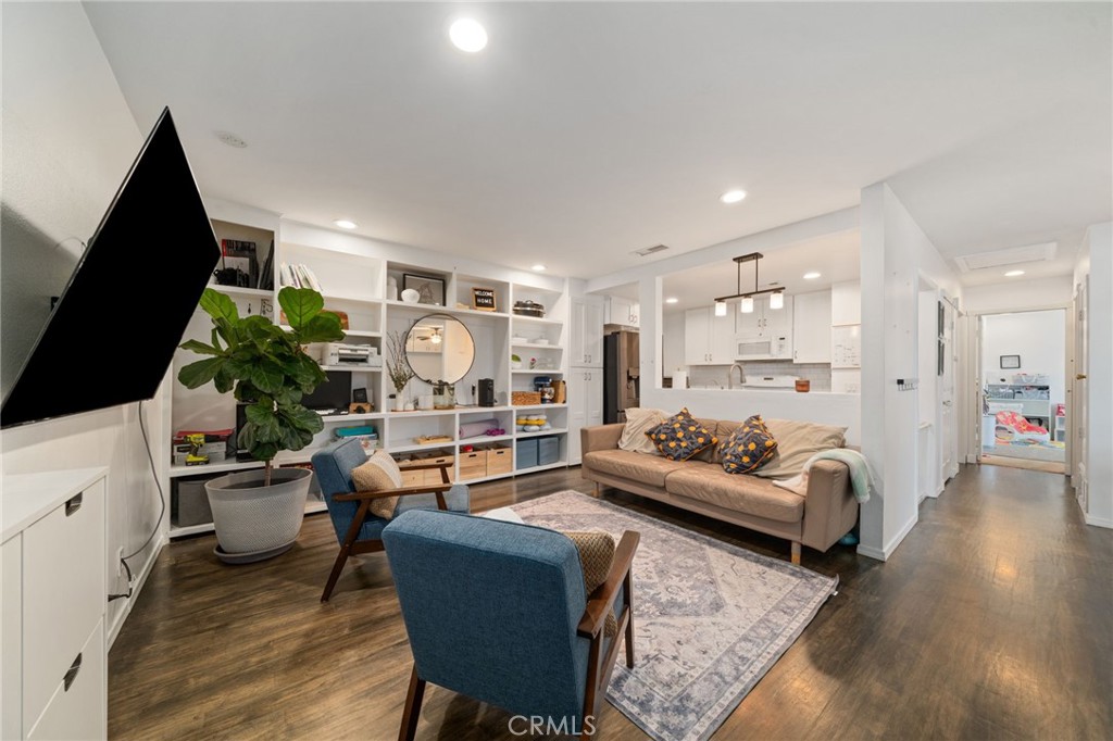 Welcome to this bright and inviting 2-bedroom upper-level condo located in the desirable Broadmoor community. This move-in ready home features an open layout with rich hardwood flooring throughout the living and dining areas, creating a warm and welcoming atmosphere. As you step inside, you're greeted by a spacious living room that opens up to a large private patio, perfect for relaxing or entertaining guests. A custom-built-in cabinet adds both functionality and a designer touch, offering extra storage and display space. The kitchen is beautifully updated with quality cabinetry, granite countertops, and a 5-burner gas range with convection oven, microwave, and dishwasher. A convenient breakfast bar connects the kitchen and living space, ideal for casual dining. Both bedrooms offer ample natural light, mirrored closet doors, and ceiling fans. The home is equipped with central heating and AC, and there's no one living below, adding extra peace and privacy. Additional features include a private 1-car garage, a covered carport, and access to a shared laundry room (serving only a few nearby units). The Broadmoor community is known for its beautifully landscaped grounds, mature trees, greenbelt areas, and peaceful walking paths. Residents also enjoy a large pool and deck area—great for summer days. Located near Cal State Fullerton, shopping, restaurants, and the local Farmers Market, with easy access to the 57 and 91 freeways, this home is ideally situated for comfort and convenience. Don’t miss the opportunity to make this beautifully cared-for condo your next place to call home.