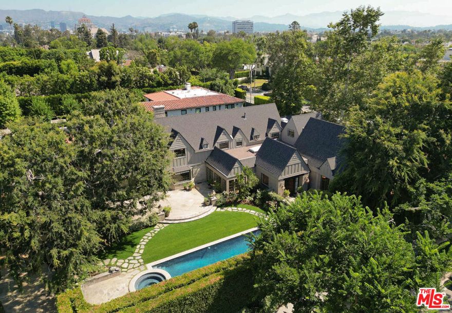 A seamless blend of old-world charm and refined elegance, the English Garden Estate offers complete privacy and security in a fully gated setting. Surrounded by enchanting gardens and park-like grounds, this expansive property rests on an impressive 18,613 SqFt lot and features 5 bedrooms and 6 bathrooms including a versatile en-suite bonus room currently used as a gym. Inside, you'll find open and inviting spaces designed for effortless entertaining: a gracious living room with a stately fireplace, a garden-view family room, a large formal dining room, a peaceful library, and a bright sunroom that fills the home with natural light. The grand chef's kitchen, anchored by an oversized center island, serves as the heart of the home, perfect for gathering with loved ones. Upstairs, the private primary suite is a true retreat, featuring a spacious sitting room, a luxurious walk-in closet, and a spa-like bathroom. Across the sun-drenched hallway are two more bedrooms, each with its own beautifully appointed bathroom. One of the bedrooms includes an adjoining sitting area or playroom, and the generous attic offers ample storage space. Outside, a sparkling pool is nestled amid the lush gardens and mature landscaping, creating a serene oasis ideal for relaxing or entertaining. This timeless estate is a rare opportunity to experience luxury, tranquility, and charm, all in one captivating residence.