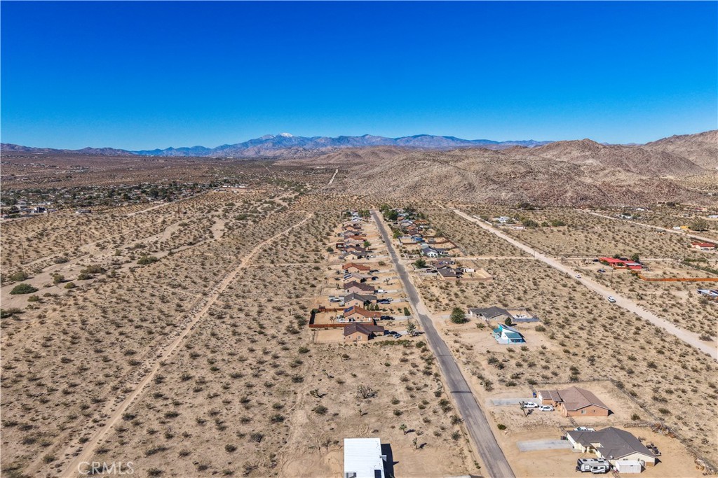 Opportunity to build your desert dream home or investment property on this spacious 18,000 square foot lot in beautiful Joshua Tree. The property offers sweeping views of the desert landscape and surrounding mountains, with ample room for creativity and privacy. Utilities are believed to be available at the street—buyer to verify.
Located close to downtown Joshua Tree, enjoy easy access to local restaurants, coffee shops, and art galleries, along with popular attractions like Joshua Tree National Park, the Joshua Tree Music Festival, and the weekly Farmers Market. Experience the unique blend of tranquility and culture that makes Joshua Tree one of the most inspiring destinations in the Hi-Desert.