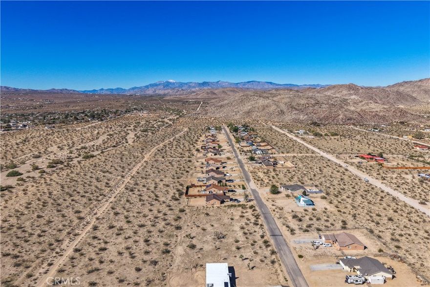 Opportunity to build your desert dream home or investment property on this spacious 18,000 square foot lot in beautiful Joshua Tree. The property offers sweeping views of the desert landscape and surrounding mountains, with ample room for creativity and privacy. Utilities are believed to be available at the street—buyer to verify.
Located close to downtown Joshua Tree, enjoy easy access to local restaurants, coffee shops, and art galleries, along with popular attractions like Joshua Tree National Park, the Joshua Tree Music Festival, and the weekly Farmers Market. Experience the unique blend of tranquility and culture that makes Joshua Tree one of the most inspiring destinations in the Hi-Desert.