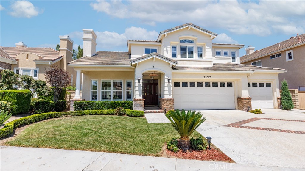 Located at the end of a quiet cul-de-sac in one of Valencia’s most sought-after neighborhoods, this stunning 5 bedroom, 4 bathroom residence offers 3,288 sq. ft. of thoughtfully designed living space and an abundance of upgrades. Step inside to a light and bright floor plan that flows seamlessly from the elegant formal living room and formal dining room to the spacious, integrated family room—complete with a custom built media niche, detailed wood ceilings, and one of the home’s three fireplaces. The heart of the home is the completely remodeled chef’s kitchen, showcasing custom wood cabinetry, granite counter tops, recessed lighting, a separate dining area, high-end stainless Fisher & Paykel appliances, including a spectacular gas range/oven with a commercial-grade ventilation hood, and designer finishes throughout. The main level also offers beautiful wood floors, a downstairs bedroom with remodeled full bath—perfect for guests or multi-generational living—an individual laundry room, and direct access to the oversized three-car garage. Upstairs, you’ll find 4 additional bedrooms, including a luxurious primary suite with a walk-in closet, remodeled bath featuring marble floors, custom vanities and mirrors, and a private retreat—ideal for a home office, meditation space, or reading lounge. Two secondary bedrooms share a Jack-and-Jill bath with a custom-tiled shower, while a spacious bedroom over the garage enjoys its own private en-suite bathroom with shower/tub.
The backyard oasis is perfect for entertaining, offering no rear neighbors and serene views of the neighborhood and lush green trees. Residents of Northbridge enjoy access to multiple association pools, parks, playgrounds, tennis courts, and miles of scenic paseo trails.This home combines timeless elegance with modern upgrades in a location that truly has it all.