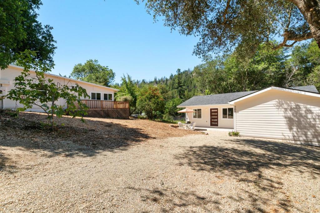 Sunny and charming Boulder Creek retreat with two versatile homes and expansive yards. Welcome to your mountain escape just one mile from downtown! Set on a spacious, sun-drenched lot, this unique property features two separate homes, each with its own privacy, character, and flexible living potential. Whether you're envisioning multi-generational living, rental income for mortgage relief and loan qualifying, guest accommodations, or a dedicated work-from-home setup, this property will meet your needs. The main home exudes cozy mountain charm ideal for full-time living, serene weekend retreat, or rental opportunity. The newly built, fully permitted ADU with mini split energy efficient heating and cooling system offers 1,052 sq ft of stylish, modern living, serving as a primary residence, guest house, extended family home, or income-generating rental. The generous yards surrounding both homes provide ample space for gardening, play, entertaining, or relaxing in the sunshine and peaceful mountain setting. Additional highlights include a brand new septic system, tranquil natural surroundings, and easy access to local hiking trails and downtown amenities. Don't miss this rare opportunity to own a versatile, character-filled property with abundant outdoor space in a prime location.
