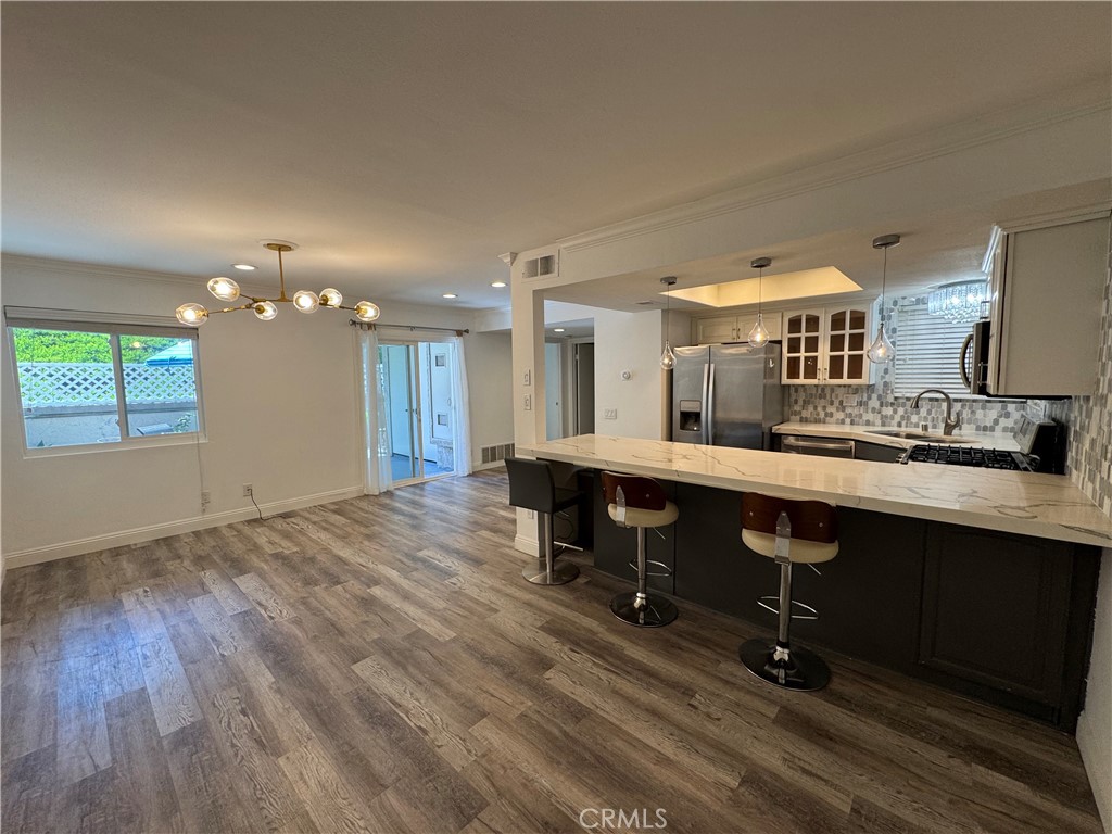 Turnkey Villa Mira Condo – Ground level, no stairs, easy entry, single level, & Move-in Ready two bedroom and two baths, approx 900 sq ft. Remodeled kitchen with quartz counters, stainless steel appliances, and recessed lighting; stylish updated baths. Open floor plan flows to a private, landscaped patio perfect for outdoor entertaining. No interior stairs. HOA recently repiped, has freshly painted exteriors, and new asphalt throughout the community. Includes deep 1-car garage, one additional assigned open parking, plus guest parking, in-home laundry, central AC/heat, engineered wood & tile floors. Resort-style amenities: 2 pools, spa, clubhouse, trails. Views of hills, and lush green vegetation from the patio and the sliding glass door from the kitchen and the master bedroom, separate entry, city lights & canyon. Prime Laguna Niguel location – near shopping, dining, freeway access (5 & 73), beaches, and top schools.