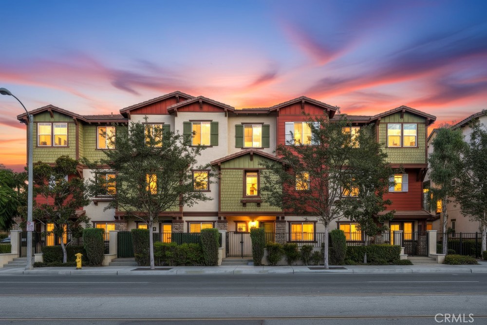 Come see this Beautiful Modern Condominium Built in 2013.  You are welcomed to this stylish and well-maintained home featuring three levels of thoughtfully designed living space. Enter from the front door or the attached two-car garage into a spacious family or entertainment room with wood flooring, custom built-in bookcases, and a convenient half bath. A lighted corner alcove provides the perfect spot for a home office or study area.  On the second floor, enjoy an open-concept main living area that combines the kitchen, dining, and living rooms—ideal for everyday living and entertaining. The kitchen features abundant cabinetry, granite countertops, a gas range with a professional energy efficient range hood, an island with sink and dishwasher, and a built-in desk area. From the spacious living room, step through the dual-pane door to a shaded balcony overlooking the neighborhood and community park. A second half bath adds convenience on this level. Upstairs, the third floor offers three bedrooms, two full baths, and a laundry closet. The spacious primary suite includes a large walk-in closet and an ensuite bathroom with dual sinks and a tub/shower combination. This home also includes numerous upgrades such as a reverse osmosis drinking water system, whole-home water softener, newer A/C (2023), replaced ducting and furnace (2024), hypoallergenic carpet, a newer gas range (2020) and dishwasher (2024). The home also features a tankless water heater and recessed lighting.  Ample storage can be found throughout the home. Enjoy access to a shaded community park and picnic area, and take advantage of the prime location close to downtown Fullerton’s vibrant SOCO District with its many shopping, dining, and entertainment options.