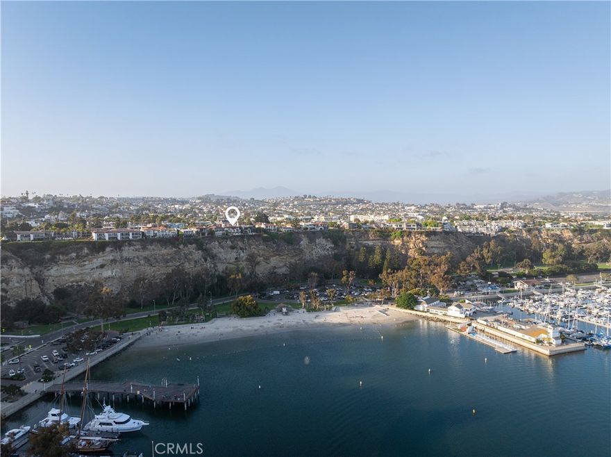 Welcome to Casa Santa Clara, an exquisite Spanish Colonial Revival estate perched atop the bluff overlooking Dana Point Harbor. Inspired by the iconic works of Wallace Neff, this custom home embodies the timeless elegance of early California architecture, seamlessly blending Old World craftsmanship with modern luxury. From the moment you step inside, sweeping panoramic ocean and harbor views captivate the senses, while the meticulous design details-hand-painted tiles, intricate wrought-iron accents, and exposed wood beams--reflect the unmistakable influence of Neff's refined aesthetic. The main house offers three beautifully appointed bedrooms, while the guest house features two additional bedrooms, creating a private retreat for visitors. These two parts of the property are connected by a stunning courtyard, where a vibrant Marlo Bartels fountain serves as the crown jewel, celebrating the rich tradition of Spanish tile artistry. Throughout the home, these intricate tiles emerge unexpectedly, adding warmth and character to the crisp, eggshell stucco exterior (originally textured by Sicilian craftsmen) all homages to Neff's architectural legacy. Designed for effortless coastal living, Casa Santa Clara spans three levels, all accessible by a private elevator. The gourmet kitchen, adorned with custom cabinetry and premium appliances, opens to an inviting dining and living area, perfect for entertaining. The primary suite is a sanctuary of its own, offering a spa-like master bathroom and a private balcony to take in the breathtaking ocean vistas. On the third level, a game room/study provides an intimate retreat with unmatched views. The guest house features a mirrored room to host a gym and a home theater in the living quarters equipped with an audio surround system. Step outside onto the expansive terraces and lushly landscaped patios, where ocean breezes and golden sunsets set the stage for al fresco dining and relaxation. With an unrivaled location just moments from Dana Point's world-class marina, pristine beaches, and the charming Lantern District, this estate offers a rare opportunity to own a piece of California's most coveted coastline. As the Dana Point Harbor Revitalization project unfolds, the future shines even brighter. Experience the pinnacle of luxury living in this Wallace Neff-inspired masterpiece. Available October 1st, 2025