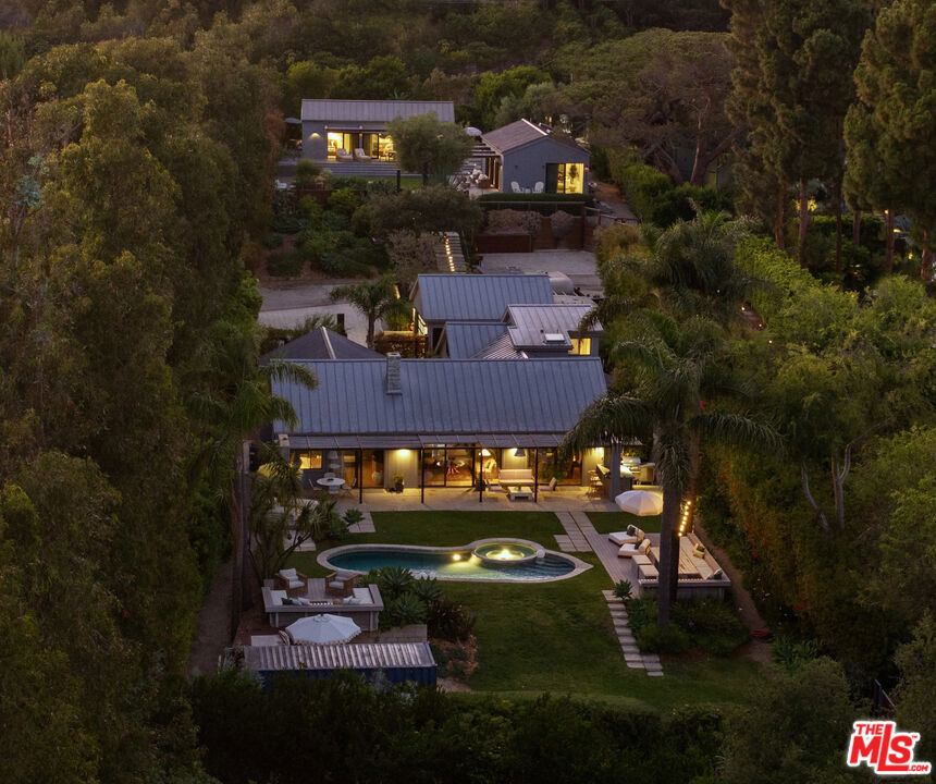 Welcome to Sea Lane Estates, Experience the pinnacle of Malibu living in this exceptional 5,000 sq. ft. coastal compound located in the exclusive enclave of Billionaire's Bluff. This five-bedroom, six-bathroom estate offers the perfect balance of relaxed luxury and family-friendly design, with sweeping ocean views, private beach access, and a resort-style atmosphere. Set behind gates, the property spans beautifully landscaped grounds with lush gardens, a saltwater pool, a spa, an outdoor kitchen, and custom fire pits, ideal for entertaining or soaking in Malibu's serene coastal lifestyle. All structures feature dramatic vaulted ceilings, designer finishes, and a standing seam metal roof, blending modern elegance with timeless coastal architecture. This ultra-private compound features three distinct structures: a spacious main house, a private guest house, and a bonus studio, perfect for extended family, guests, or a home office/studio. Indoor-outdoor flow is seamless, with walls of glass opening to expansive patios and lawn areas that invite year-round enjoyment. With direct access to the sand and surf of one of Malibu's most coveted beaches, this is a rare opportunity to own a legacy property in one of the most prestigious coastal communities in the world.