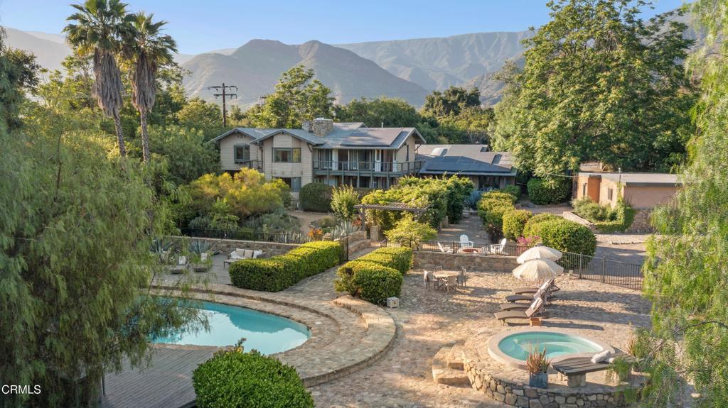 A rare offering in Ojai's coveted East End, 4158 Grand Avenue is a soulful 5-bedroom, 6-bathroom estate tucked behind mature trees and citrus groves for a sense of seclusion and quiet. Spanning over an acre, this serene retreat blends historic charm with modern luxury in one of the valley's most sought-after enclaves.Inside, sunlit interiors and handcrafted architectural details create a sense of warmth and timelessness. Five fireplaces anchor expansive living spaces, ideal for both intimate gatherings and large-scale entertaining. The generous primary suite is a true retreat, featuring dual en-suite baths, a private sauna, and abundant closets. Each additional bedroom includes its own en-suite bath, offering comfort and privacy for family and guests.Outdoors, enjoy lush, manicured grounds with a sparkling pool, spa, and a shaded patio for dining al fresco beneath the trees. The detached three-car garage includes an art studio, laundry area, and full bath--perfect for creative pursuits or poolside entertaining. A charming one-bedroom ADU offers flexibility for guests or income.Moments from Ojai's farmers markets, trailheads, and celebrated restaurants, this is a home for those who value beauty, privacy, and place.