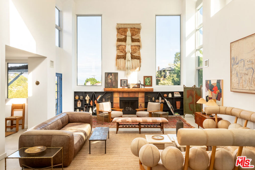 Modern Architectural Retreat with Panoramic Mountain Views. Inspired architecture meets creative flexibility on one of Mount Washington's most desirable streets. Behind 75' of gated frontage, 4006 San Rafael Ave is a stunning post-modern residence offering dramatic scale and thoughtful design. Spanning 4,500 square feet with 4 bedrooms and 3.5 baths, plus a 510-square-foot detached creative studio with its own bath, the home blends form, function, and inspiration. The double-height living room serves as the centerpiece, showcasing soaring windows that frame sweeping mountain vistas, a decorative fireplace, and custom built-ins. An open-concept great room connects the dining area with a striking chef's kitchen featuring a curved seating bar, oversized island, designer lighting, and walk-in pantry - an ideal setting for entertaining and everyday living. Close by is the shaded terrace, overlooking snow-capped Mount Baldy and the San Gabriel Mountains. Upstairs, the primary suite offers a private sanctuary with its own balcony, walk-in closet, and a spa-like bath complete with soaking tub, glass-enclosed shower, and dual vanities. Just steps away, a flex space doubles as a nursery, office, or lounge. Two secondary bedrooms share a full bath in their own quiet wing. The lower level expands the living options with a cozy den for movie nights, an additional flex space perfect for a gym or playroom, a fourth bedroom, full bath, and generous storage. Outdoors, the terraced yard invites connection and creativity with areas for dining, play, and gardening, surrounded by mature fruit trees. The detached studio, currently used as a music space, enhances the home's artistic energy and versatility. A rare combination of architecture, comfort, and location just moments from Mount Washington Elementary (TK-6), and minutes to scenic hiking trails like Moon Canyon and Elyria Canyon, and neighborhood favorites along Figueroa and York Boulevards. Easy access to the 110 freeway keeps the rest of Los Angeles and Pasadena within reach. 4006 San Rafael Ave - a place to grow, create, and truly live.