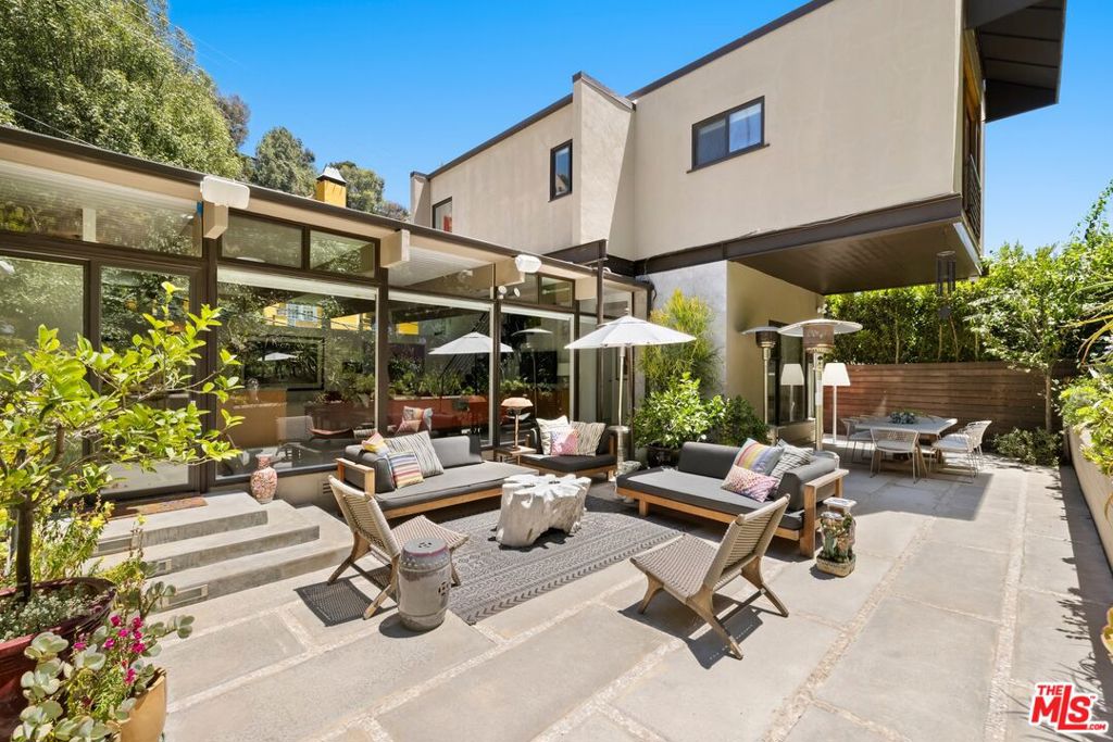 Beautifully updated post and beam modern home nestled in one of Los Angeles' most sought-after neighborhoods. Originally built in the 1950s, this five-bedroom, three-bathroom residence showcases timeless mid-century architecture enhanced by thoughtful modern updates throughout. The main level features open-concept living spaces bathed in natural light, with exposed wood beams and floor-to-ceiling windows that create a seamless indoor-outdoor connection. The gourmet kitchen flows effortlessly into the dining and living areas, making it ideal for both everyday living and entertaining. The entire second level is dedicated to the primary suite that includes a large bedroom, spa-inspired en-suite bathroom, and an adjoining room perfect for a home office, nursery, or bedroom. This home is offered fully furnished with beautifully curated, high-end furnishings and tasteful artwork throughout. Outside, the lushly landscaped backyard offers a peaceful escape with multiple areas for outdoor dining, lounging, and entertaining. Whether hosting guests or enjoying a quiet evening under the stars, the setting is private, inviting, and serene. Additional highlights include a two-car carport, excellent street parking, and close proximity to some of Los Angeles' best hiking trails. Located within the coveted Wonderland Avenue School district and just minutes from premier dining, shopping, and entertainment, this exceptional home is ideal for both families and entertainers and offers the perfect balance of tranquil, stylish living and vibrant city access.