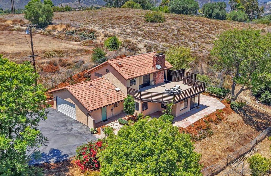 Major price reduction!! This spectacular solar-powered, gated horse property offers an incredible opportunity for both equestrian enthusiasts and those seeking a private, serene retreat. Nestled on a sprawling lot, the home provides awe-inspiring panoramic views that you can enjoy from the expansive deck, patio, or almost any room in the house. The beautifully designed 3-bedroom, 2-bathroom main home exudes warmth and charm, featuring a comfortable and inviting floor plan. The living room, complete with a cozy fireplace, provides the perfect space to relax while taking in the scenic surroundings. Large picture windows bathe the space in natural light and offer uninterrupted views of the rolling hills. The chef’s kitchen is fully equipped with custom cabinetry, high-end appliances, and a charming eat-in dining area that flows seamlessly into the living room for easy entertaining. The main floor also includes 2 spacious bedrooms and a full bathroom featuring a large wrap-around shower with a skylight. The entire upper level is dedicated to the luxurious primary suite. This private retreat boasts a large bedroom with a cozy fireplace and an expansive walk-in closet with custom storage solutions. The primary en suite bathroom is equally impressive, with dual sinks, a large walk-in shower, and beautiful finishes. The spacious deck off the bedroom extends the living space, offering breathtaking views and truly a place to unwind and rejuvenate. This property is a horse lover’s dream, offering a well-appointed barn with everything you need for your equestrian lifestyle. The barn includes four stalls - three with turnouts and one foaling stall, along with a wash rack, tack room, and a spacious arena. Thick rubber mats cover the stall floors, and hot and cold water is readily available in the barn, making it fully functional for everyday use. There are also three separate paddocks, allowing ample space for horses to roam freely. Attached to the barn is a one-bedroom studio with a 3/4 bath and kitchen area, offering a comfortable space for guests, staff, or an office. Two additional storage sheds provide ample room for feed and tack, ensuring that everything can be neatly organized and easily accessible. Solar power is provided by 33 owned panels that are paid in full, providing both energy efficiency and peace of mind. In addition to the equestrian amenities, this estate also boasts a spacious RV carport for easy parking and storage. Whether you’re enjoying a quiet evening by the fire or tending to your horses, this property offers the ultimate in privacy, comfort, and convenience. Located in a peaceful, highly desirable area, this property is just a short drive (or even a walk!) to Fallbrook’s downtown shopping, dining, and local attractions, while still offering the tranquility and seclusion you crave. Don’t miss the chance to make this dream home yours - schedule a tour today and experience the beauty and serenity that await!