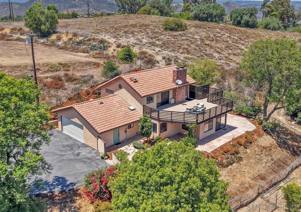 This spectacular gated horse property offers an incredible opportunity for both equestrian enthusiasts and those seeking a private, serene retreat. Nestled on a sprawling lot, the home provides awe-inspiring panoramic views that you can enjoy from the expansive deck, patio, or almost any room in the house. The beautifully designed 3-bedroom, 2-bathroom main home exudes warmth and charm, featuring a comfortable and inviting floor plan. The living room, complete with a cozy fireplace, provides the perfect space to relax while taking in the scenic surroundings. Large picture windows bathe the space in natural light and offer uninterrupted views of the rolling hills. The chef’s kitchen is fully equipped with custom cabinetry, high-end appliances, and a charming eat-in dining area that flows seamlessly into the living room for easy entertaining. The main floor also includes 2 spacious bedrooms and a full bathroom featuring a large wrap-around shower with a skylight. The entire upper level is dedicated to the luxurious primary suite. This private retreat boasts a large bedroom with a cozy fireplace and an expansive walk-in closet with custom storage solutions. The primary en suite bathroom is equally impressive, with dual sinks, a large walk-in shower, and beautiful finishes. The spacious deck off the bedroom extends the living space, offering breathtaking views and truly a place to unwind and rejuvenate. This property is a horse lover’s dream, offering a well-appointed barn with everything you need for your equestrian lifestyle. The barn includes four stalls - three with turnouts and one foaling stall, along with a wash rack, tack room, and a spacious arena. Thick rubber mats cover the stall floors, and hot and cold water is readily available in the barn, making it fully functional for everyday use. There are also three separate paddocks, allowing ample space for horses to roam freely. Attached to the barn is a one-bedroom studio with a 3/4 bath and kitchen area, offering a comfortable space for guests, staff, or an office. Two additional storage sheds provide ample room for feed and tack, ensuring that everything can be neatly organized and easily accessible. Solar power is provided by 33 owned panels that are paid in full, providing both energy efficiency and peace of mind. In addition to the equestrian amenities, this estate also boasts a spacious RV carport for easy parking and storage. Whether you’re enjoying a quiet evening by the fire or tending to your horses, this property offers the ultimate in privacy, comfort, and convenience. Located in a peaceful, highly desirable area, this property is just a short drive (or even a walk!) to Fallbrook’s downtown shopping, dining, and local attractions, while still offering the tranquility and seclusion you crave. Don’t miss the chance to make this dream home yours - schedule a tour today and experience the beauty and serenity that await!