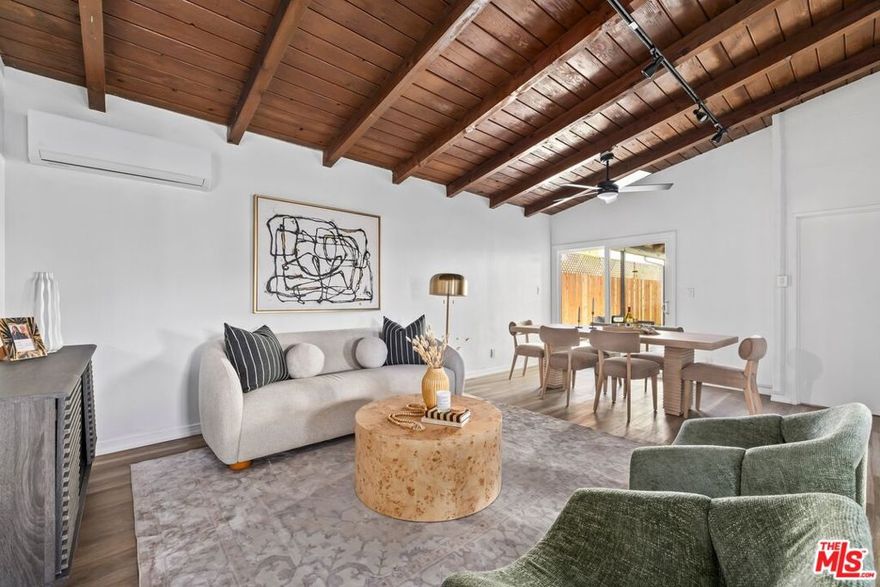 Tucked at the end of a cul-de-sac, this renovated mid-century modern Culver City home features 3-bedrooms, 2-bathrooms and thoughtful modern upgrades throughout. Step inside to an airy, open floor plan under vaulted wood-beamed ceilings, where the spacious living room flows seamlessly to the kitchen and a covered backyard patio, perfect for morning coffee or evening relaxation. Quartz countertops, stainless steel appliances, and a farmhouse-style sink elevate the bright kitchen. Just off the living area, two bedrooms share a beautifully updated bathroom, ideal for family, guests, or a home office. The primary suite sits on the opposite wing of the home, offering dual closets and a remodeled bathroom with quartz counters, a double vanity, and a glass enclosed shower. Outdoor space wraps around the home with multiple areas for entertaining and outdoor dining. The covered patio off the living room opens to a fenced turf backyard framed by greenery and palm trees, while the side yard provides even more outdoor space. Additional highlights include new flooring throughout, fresh paint, new windows, and new mini-split AC units, while direct access to the garage adds everyday convenience. With plentiful parking and ample private space, this location offers rare seclusion without sacrificing convenience. Moments from shops and dining, Downtown Culver City, Marina del Rey, Santa Monica, and LAX, this home places the best of Westside living within easy reach.