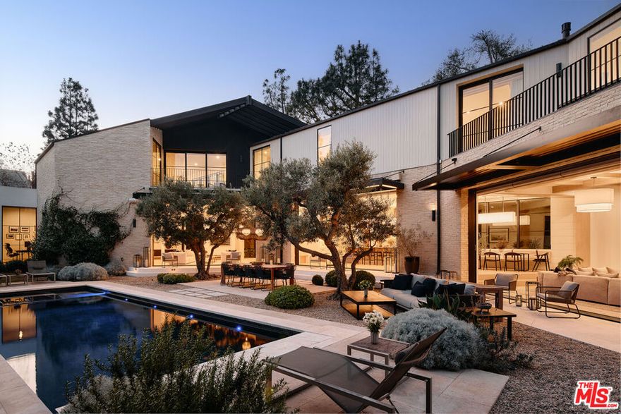 Modern Elegance in Beverly Hills: Nestled in the heart of Beverly Hills, this stunning architectural estate is a testament to masterful design and unparalleled craftsmanship. Tucked behind a gated driveway, this expansive residence combines organic materials, a meticulously curated floor plan, and enchanting landscaping to create a private oasis of luxury and serenity. Sophisticated Main Level: The home's main level welcomes you with a dramatic entryway leading to an open-concept living room flooded with natural light. The intimate formal dining room, adorned with hand-plastered walls, exudes warmth and sophistication. A chef's dream, the large professional kitchen features a striking stone center island, walk-in storage, and a butler's pantry, seamlessly connecting to a charming breakfast nook. Adjacent to the kitchen, a cozy family room and a private office enhance everyday functionality. A guest bedroom suite, powder room, and a well-appointed mudroom with direct access to the three-car garage complete this level. The piece de resistance  is the sculptural staircase, a true showpiece, complemented by a hotel-worthy elevator providing effortless access to all floors. Elegant Upper Level: Ascending to the upper level, you'll find a chic conversation area opening onto a balcony with verdant treetop views. The substantial primary suite impresses with a serene ambiance, a luxurious stone-clad bathroom, and an oversized walk-in closet. Three additional bedroom suites feature soaring ceilings, abundant natural light, and impeccable finishes. For convenience, a thoughtfully designed upstairs laundry station is also included. Entertainer's Paradise on the Lower Level: The lower level is a haven for recreation and entertainment. Highlights include a professional sound booth, a state-of-the-art gym with a full bath and steam shower, and a game room that seamlessly transitions into an inviting entertaining lounge. A tiered private theater with its own outdoor gathering space ensures an elevated cinematic experience. This level also offers a full guest suite and an oversized laundry room for maximum functionality. Outdoor Living at Its Finest: The backyard is a seamless extension of the home's main living spaces, blending luxury and nature. Lush landscaping frames the alfresco dining area, outdoor BBQ, and a sparkling pool and spa. A vegetable garden adds a touch of charm, while a dedicated wellness retreat with a cold plunge, sauna, and outdoor shower creates a sanctuary for relaxation and rejuvenation. The Ultimate Statement in Luxury Living: This bespoke estate is a triumph of design and detail, offering every conceivable amenity for those who demand nothing less than perfection. A rare opportunity to own a truly exceptional home in one of the world's most coveted locations.