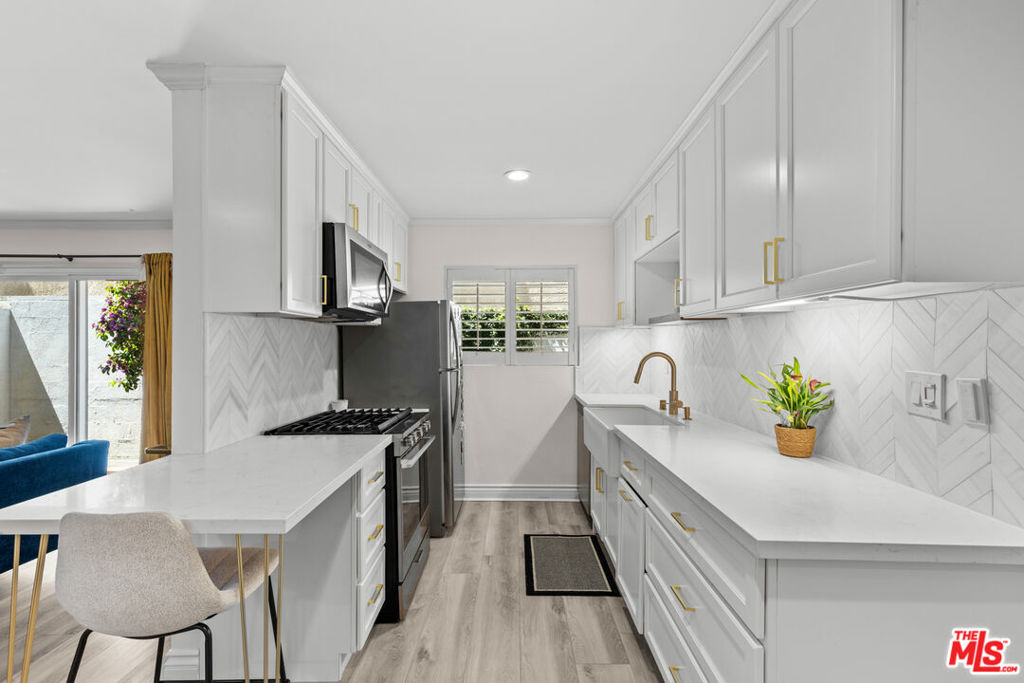 Back on The Market- no fault to seller. Welcome to your dream home WITH ONE OF THE LOWEST HOA'S in the area, a charming two-bedroom, two-bathroom condo located just moments from the bustling Ventura Boulevard. This beautifully upgraded residence perfectly combines modern conveniences with a touch of elegance, offering easy access to a myriad of restaurants, shops, and quick freeway connections. The meticulously remodeled kitchen is the heart of the home, featuring sleek quartz countertops, new cabinetry, a stylish backsplash, and state-of-the-art appliances, making it ideal for both cooking enthusiasts and those who love to entertain. The inviting living area is enhanced with custom additions, including an electric fireplace with an entertainment shiplap extension and custom cabinetry for your TV, creating a cozy yet sophisticated atmosphere. Every detail has been thoughtfully considered, from the new sliding glass door with drapes to the recessed lighting and new crown molding and baseboards. The spacious outdoor patio, complete with a new wood deck and a charming garden, offers a peaceful retreat for relaxation. Additional upgrades include new flooring and drywall downstairs, new windows throughout, and freshly painted walls in key areas, all of which contribute to the condo's modern and refreshed look. Efficiency and functionality are at the forefront of this condo's design, as evident in the convenient in-unit laundry facilities with custom storage and the tastefully remodeled downstairs bathroom, featuring new flooring, a customized floating sink, and modern fixtures. Space-saving enhancements, such as pocket doors and a new front door, contribute to the home's sleek appearance. The upgraded HVAC system ensures comfort, while the new drywall and ceiling in the main bedroom add to the condo's appeal. Don't miss this opportunity to own a piece of real estate that perfectly balances comfort, style, and convenience amidst a vibrant urban setting. Schedule your viewing today!