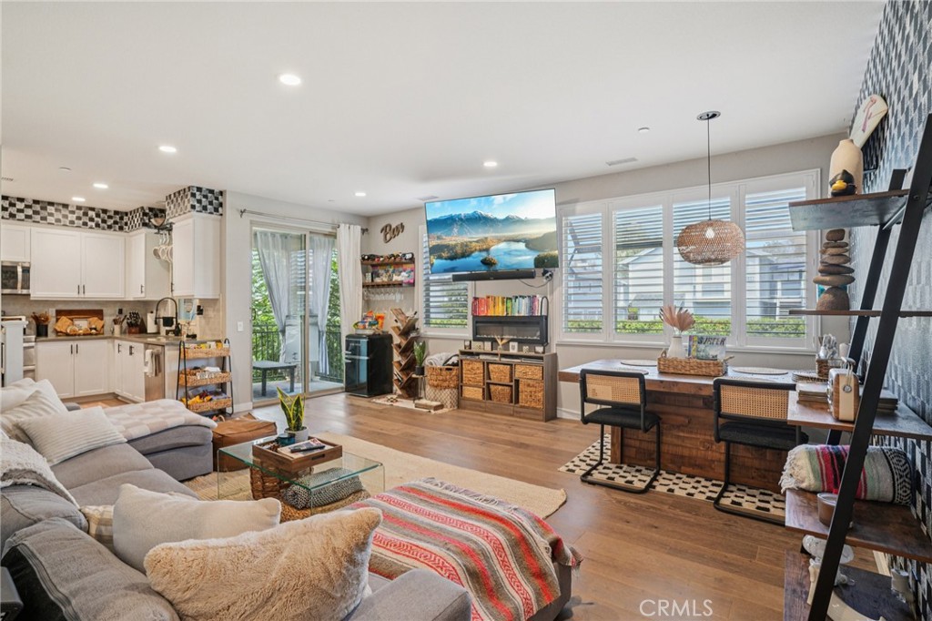 Gorgeous Upgraded End-Unit Home! Built in 2017, this spacious 3-bedroom, 3-bathroom residence offers 1,710 sq. ft. of modern living across 3 levels. The open floor plan showcases high-end custom wood flooring, plush carpet, plantation shutters, and abundant natural light throughout. The upgraded kitchen features sleek finishes and seamlessly flows into the dining and living areas, perfect for entertaining. Bathrooms are beautifully updated with designer touches. Enjoy the convenience of an attached 3-car tandem garage and an interior laundry room. The tankless water heater has "On Demand" hot water controls. Relax on the charming private patio or take advantage of the prime location—just steps from shops, dining, and everyday conveniences. With NO MELLO ROOS, low HOA and low-maintenance living, this stunning home is the perfect blend of style, comfort, and convenience.