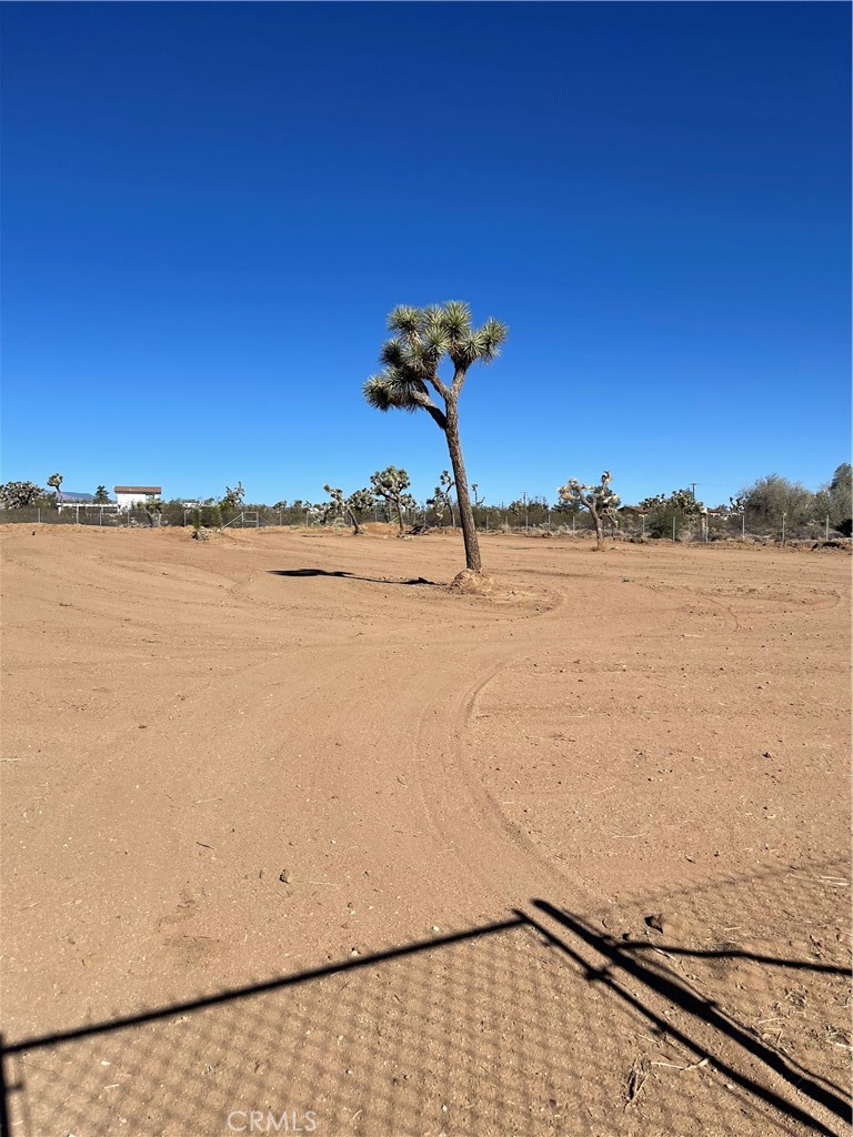Flat, buildable parcel located at Indio Ave & Canterbury St in the Mesa area of Yucca Valley. Property is fully fenced with double-gated access and offers sweeping views of Bartlett Mountain and Joshua Tree National Park. Enjoy vibrant sunrises, star-filled nights, and minimal light pollution. Electric and water are at the street (buyer to verify). Just 20 minutes to Joshua Tree National Park and 40 minutes to Palm Springs. Ideal for a custom home, weekend retreat, or investment.